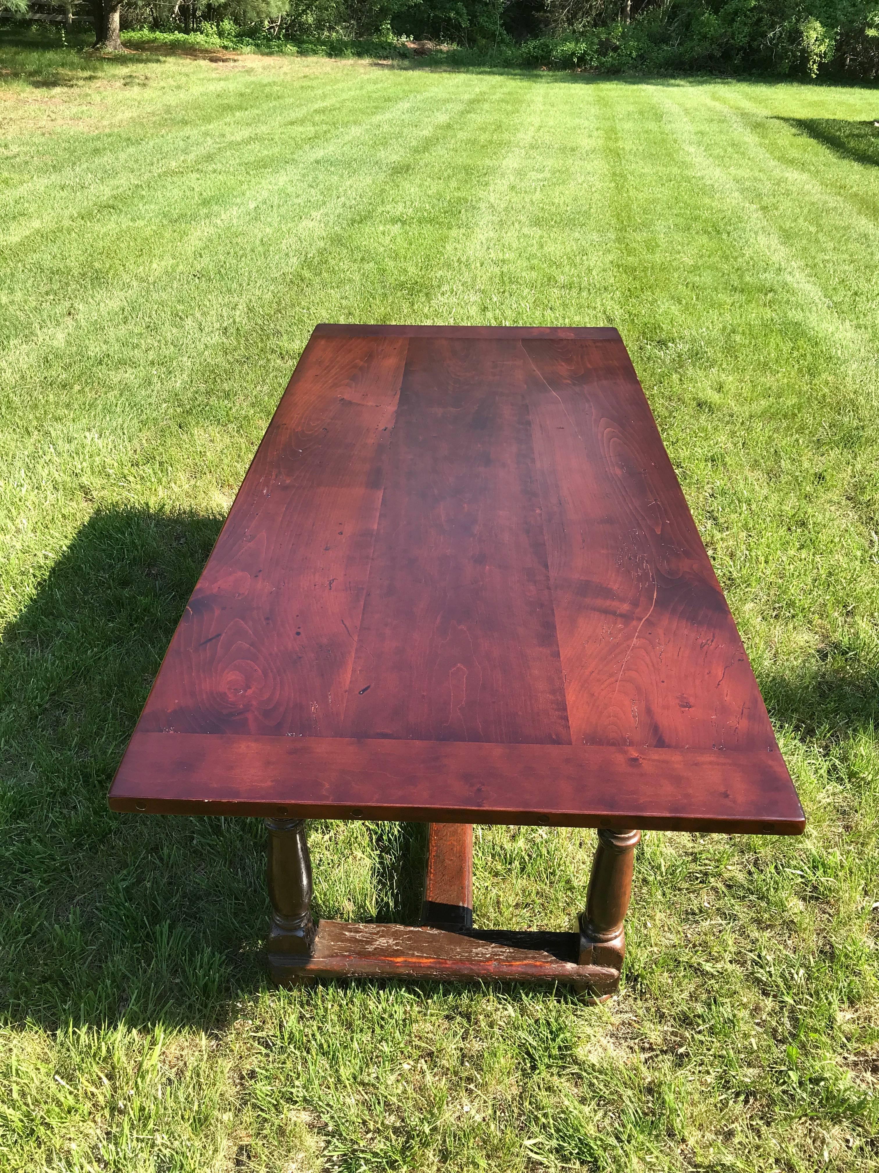 English tavern table, late 18th century. Walnut trestle, turned leg base with a cherry, bread board top. Functional drawers at both ends, one affixed with a wooden knob and other with a metal ring pull. Table top recently repaired and refinished,