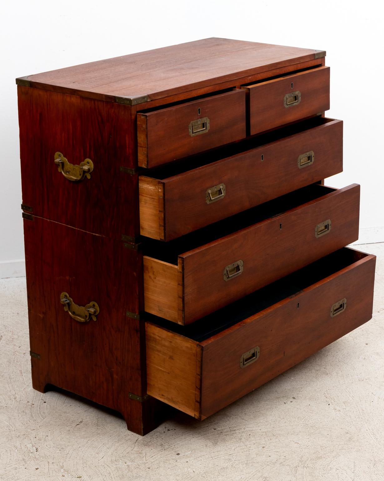 Circa mid 19th century two section English campaign chest on bracket feet and composed of teak and pine woods. The piece also features with recessed metal handles on the drawer fronts and bat's wing escutcheoned handles on the sides for portability.