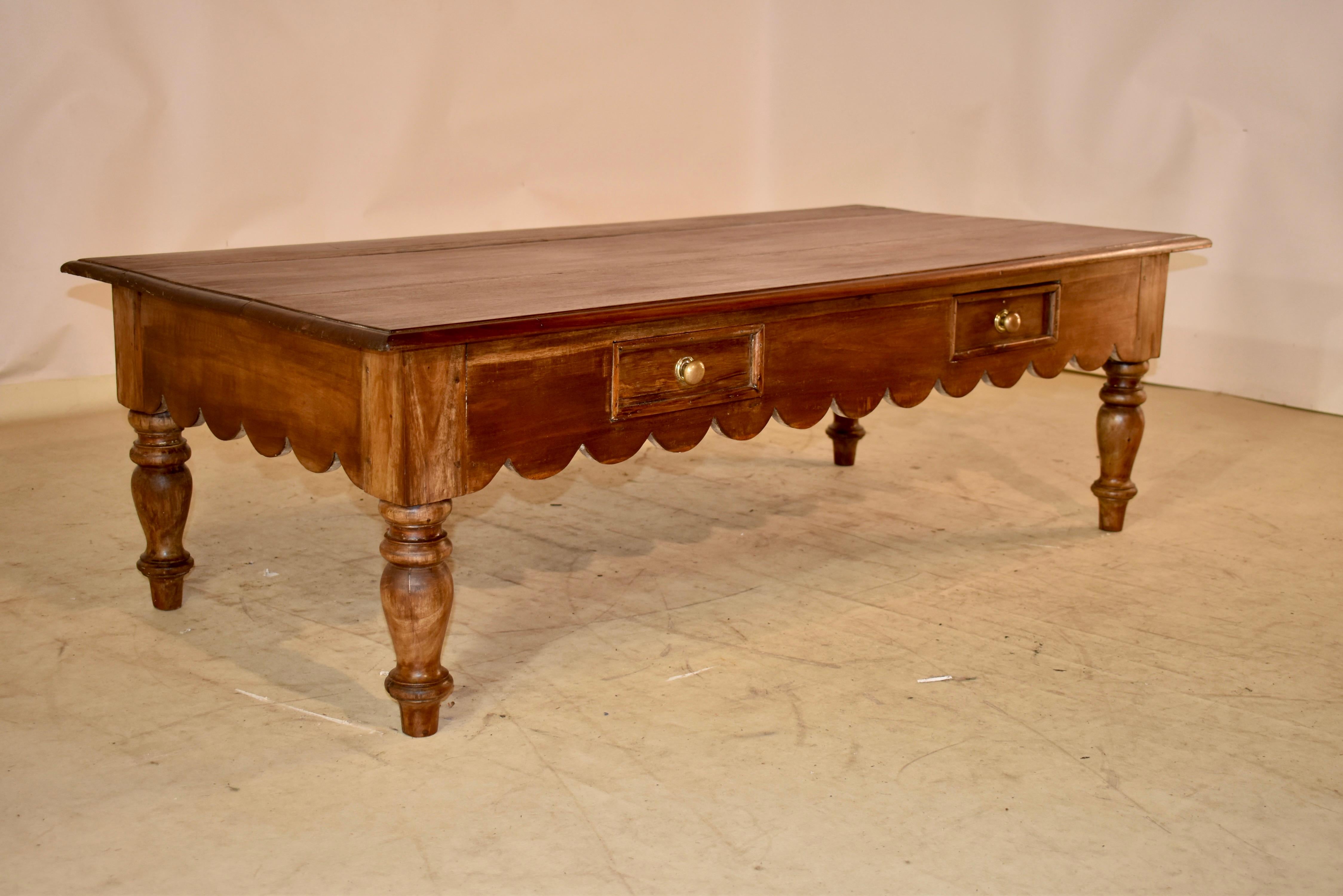 Rustic teak coffee table from England, circa 1900-1920.  The top is made from planks and has a refined beveled edge.  The aprons are simple and have hand scalloping along the bottom edges for added design interest.  There are two drawers in the