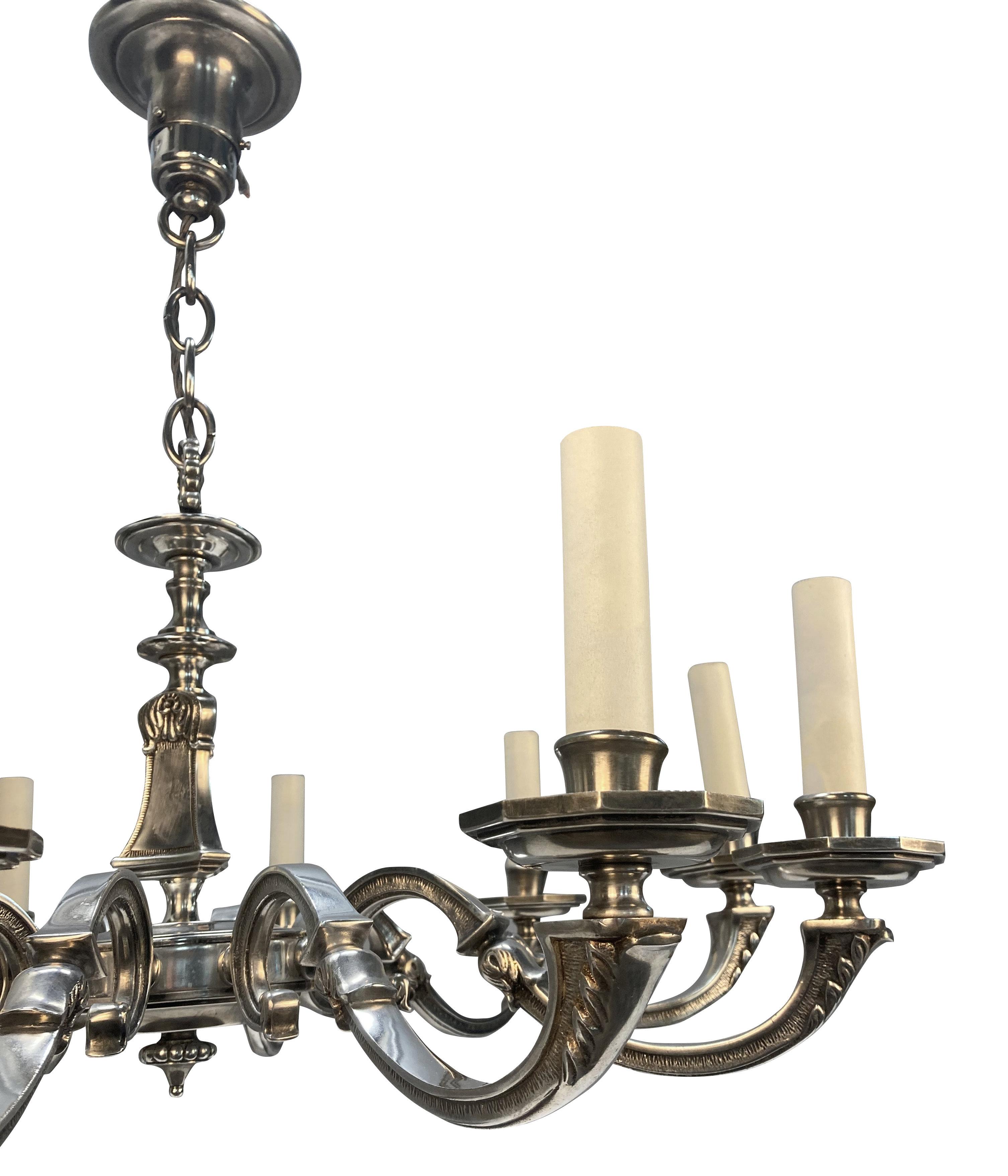 Un lampadario neoclassico inglese a dieci rami argentati, poco profondo e adatto a soffitti bassi.