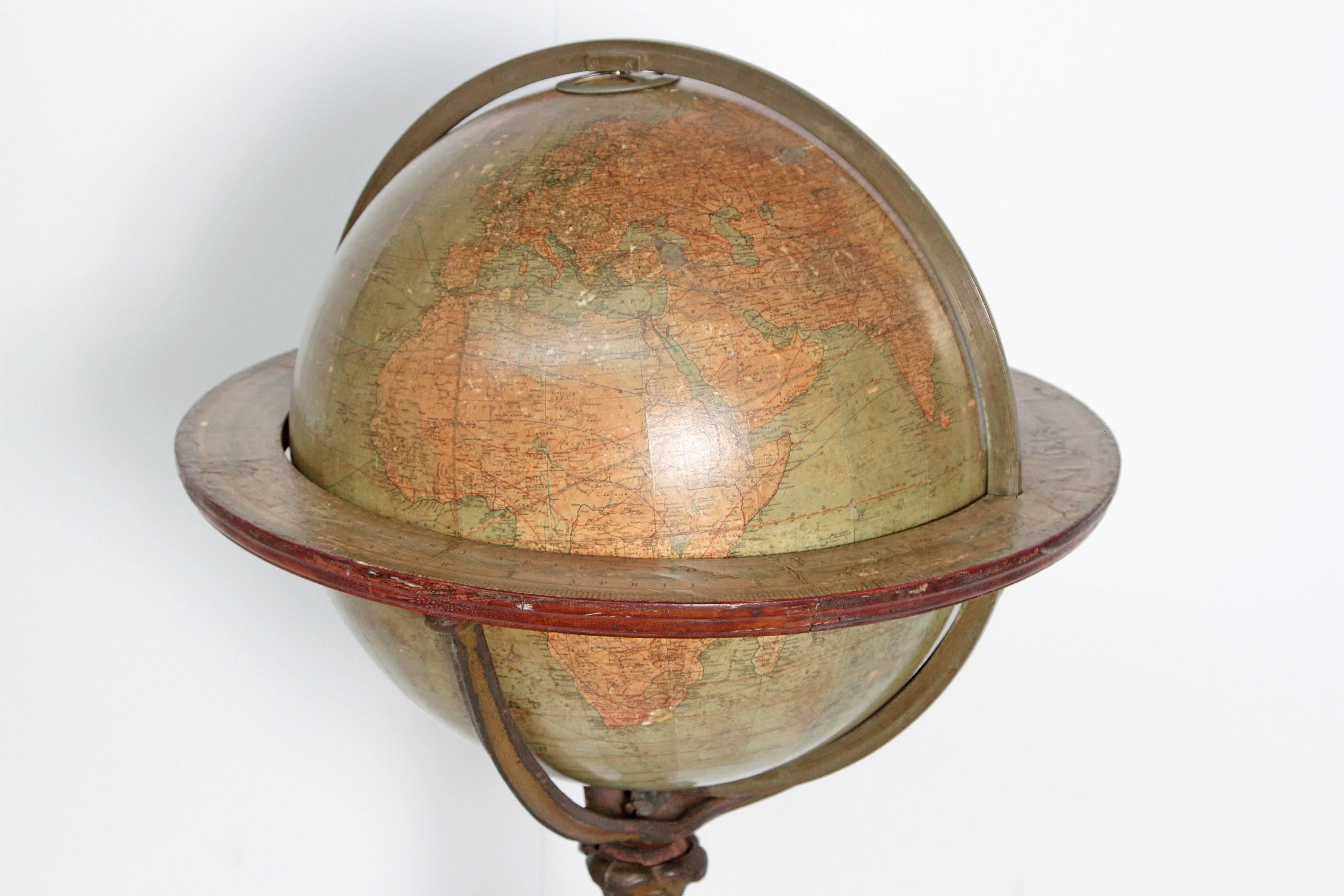 English terrestrial globe on stand by W. & A.K. Johnston, Limited, Geographers; Engravers & Printers, Edinburgh and London. Exquisite cast iron acanthus leaf tripod floor stand base on castors, circa 1890.
 