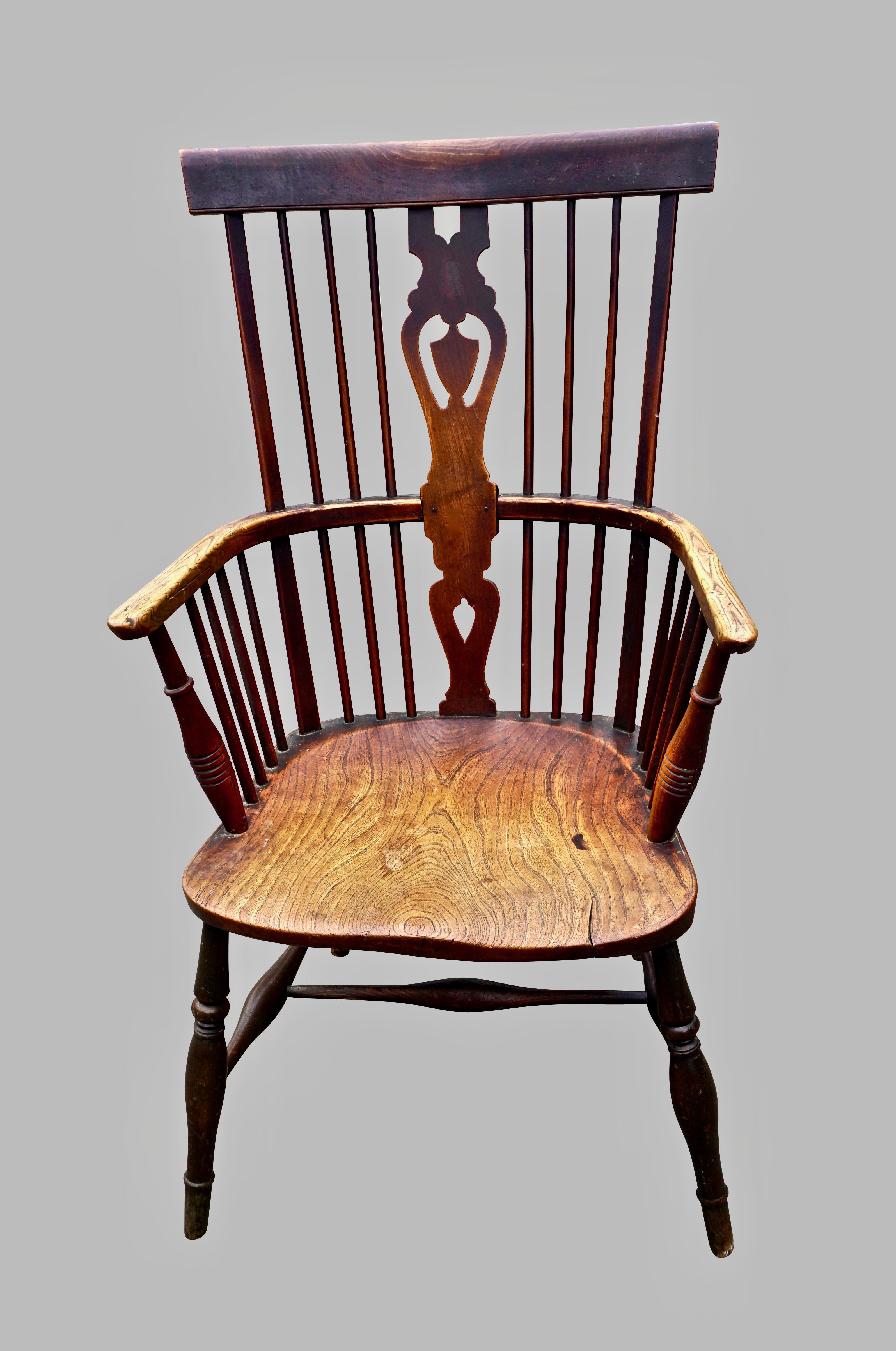 An English Thames Valley Windsor armchair of typical form with a pieced vasiform central splat terminating at the curved crest rail, the elm saddle seat supported on turned legs jointed by a single stretcher. Retains a crusty original surface that