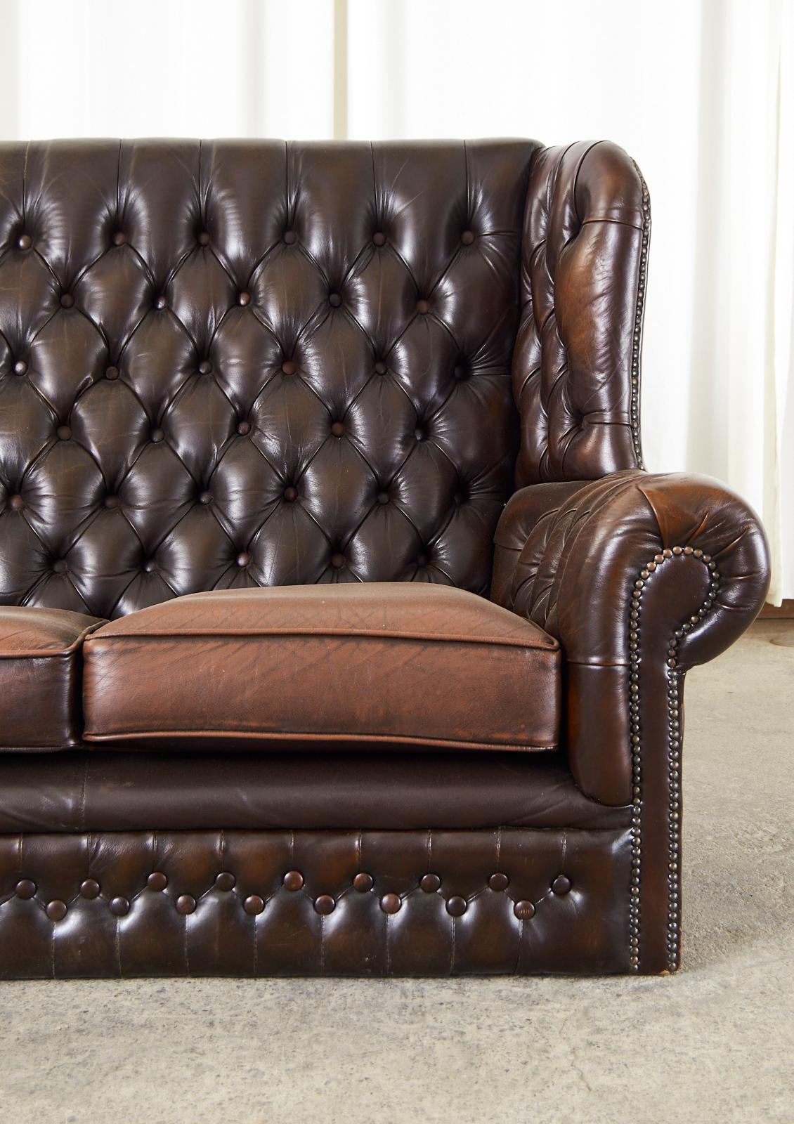 English Thomas Lloyd Cigar Leather Wingback Chesterfield Settee In Distressed Condition For Sale In Rio Vista, CA