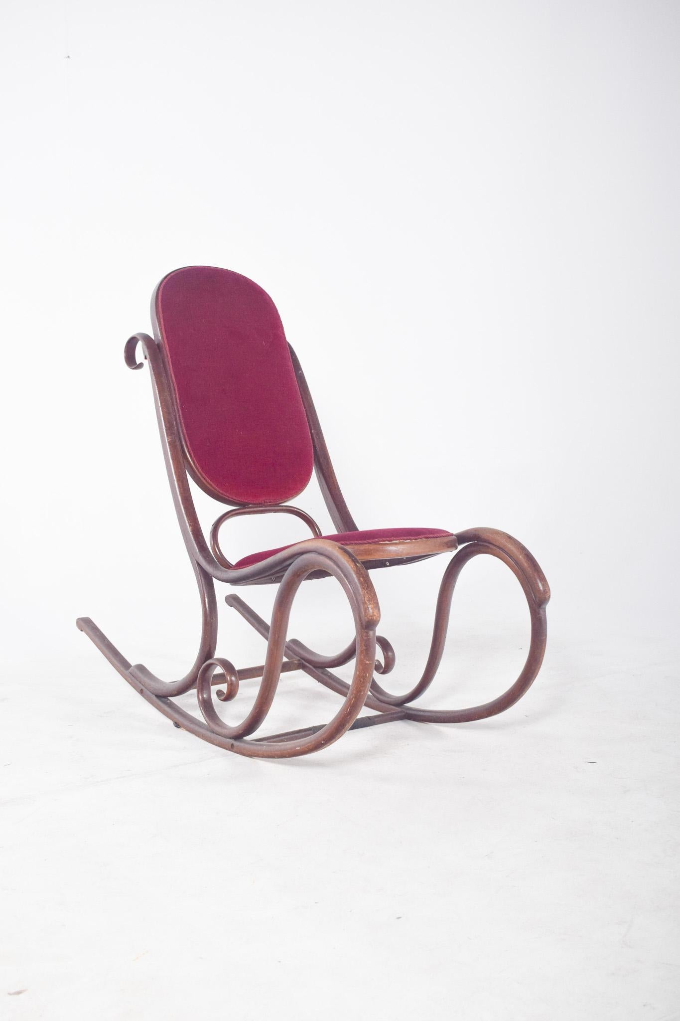 Sedia a dondolo in stile Thonet.  La struttura è composta da pezzi sinuosi e intrecciati in eleganti forme circolari e curve, un segno distintivo dei mobili in vimini piegati a vapore sviluppati nel XIX secolo. Lo schienale alto e leggermente