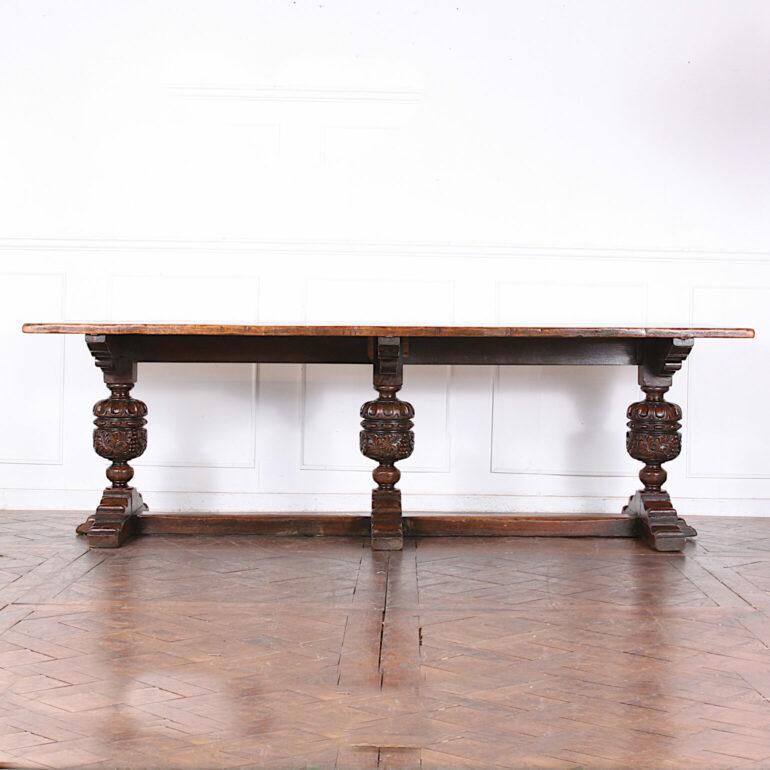 A particularly well-made fine quality solid oak trestle with a triple pedestal base. Comprised of solid English plank-oak top, sitting on heavy turned and carved legs, each with. Long enough to take four chairs down each side. A handsome and