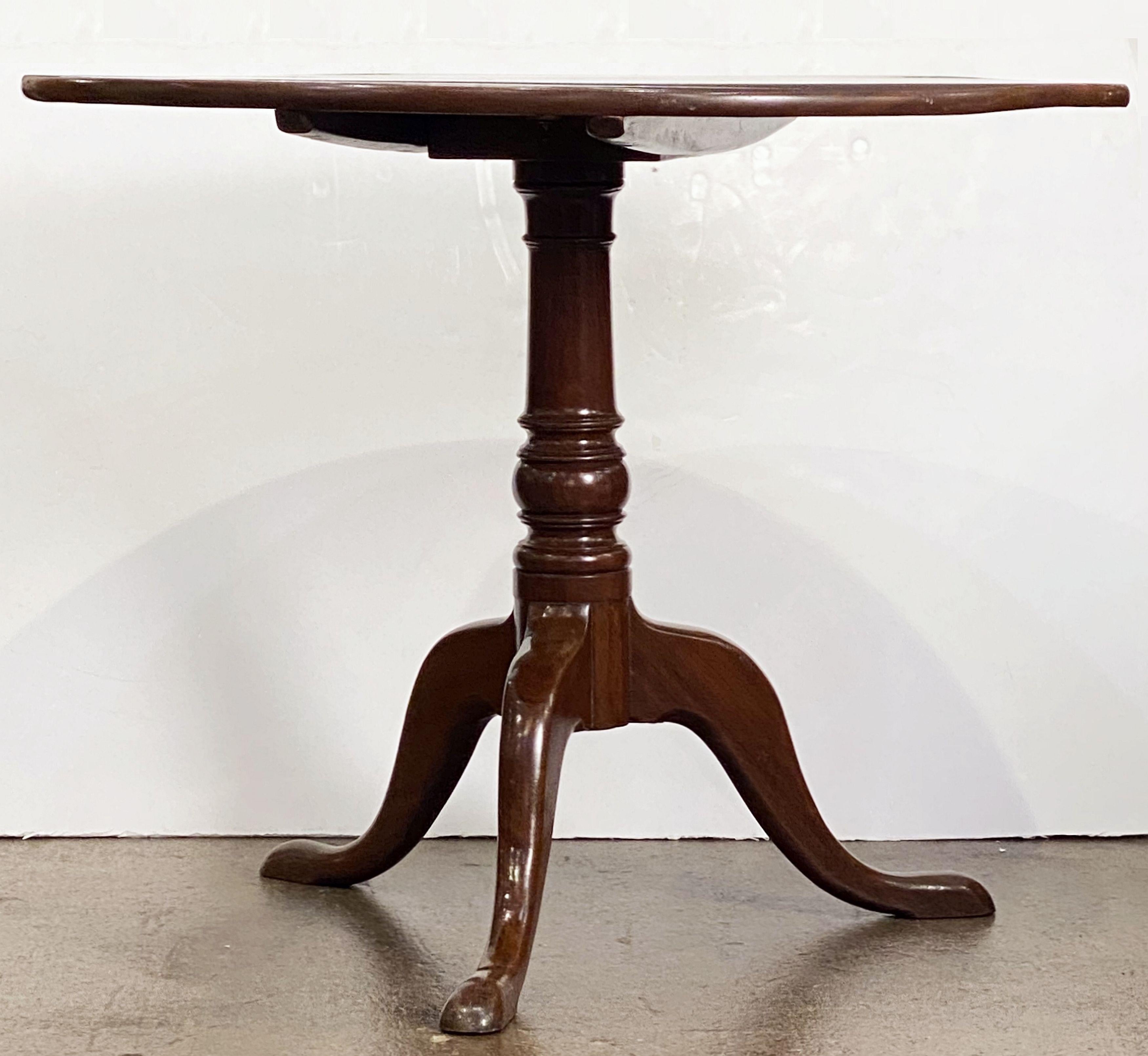 An English tilt-top table of mahogany featuring a round top mounted to a turned column pedestal with tripod base and pad-foot legs. 
With original brass hardware.

Great for use as a breakfast or sofa table.