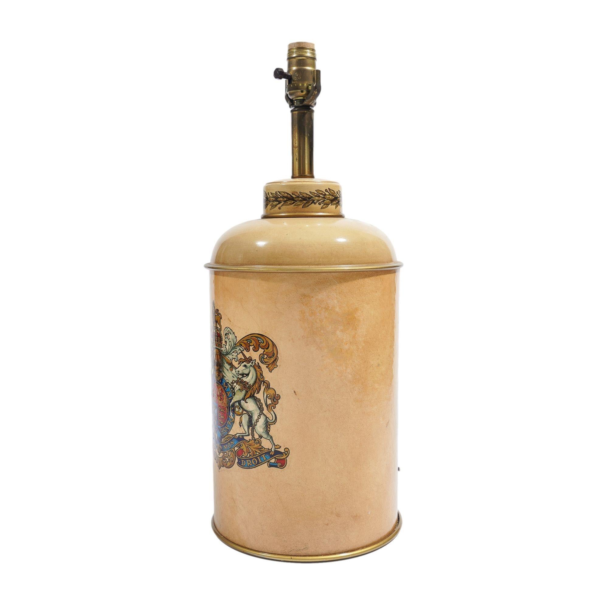 Tole tea canister painted with an ivory ground and transfer print of the British coat of arms, electrified for use as a lamp.
England, mid-20th century.

Dimensions: 8-3/4” W x 22” H (to top of socket)