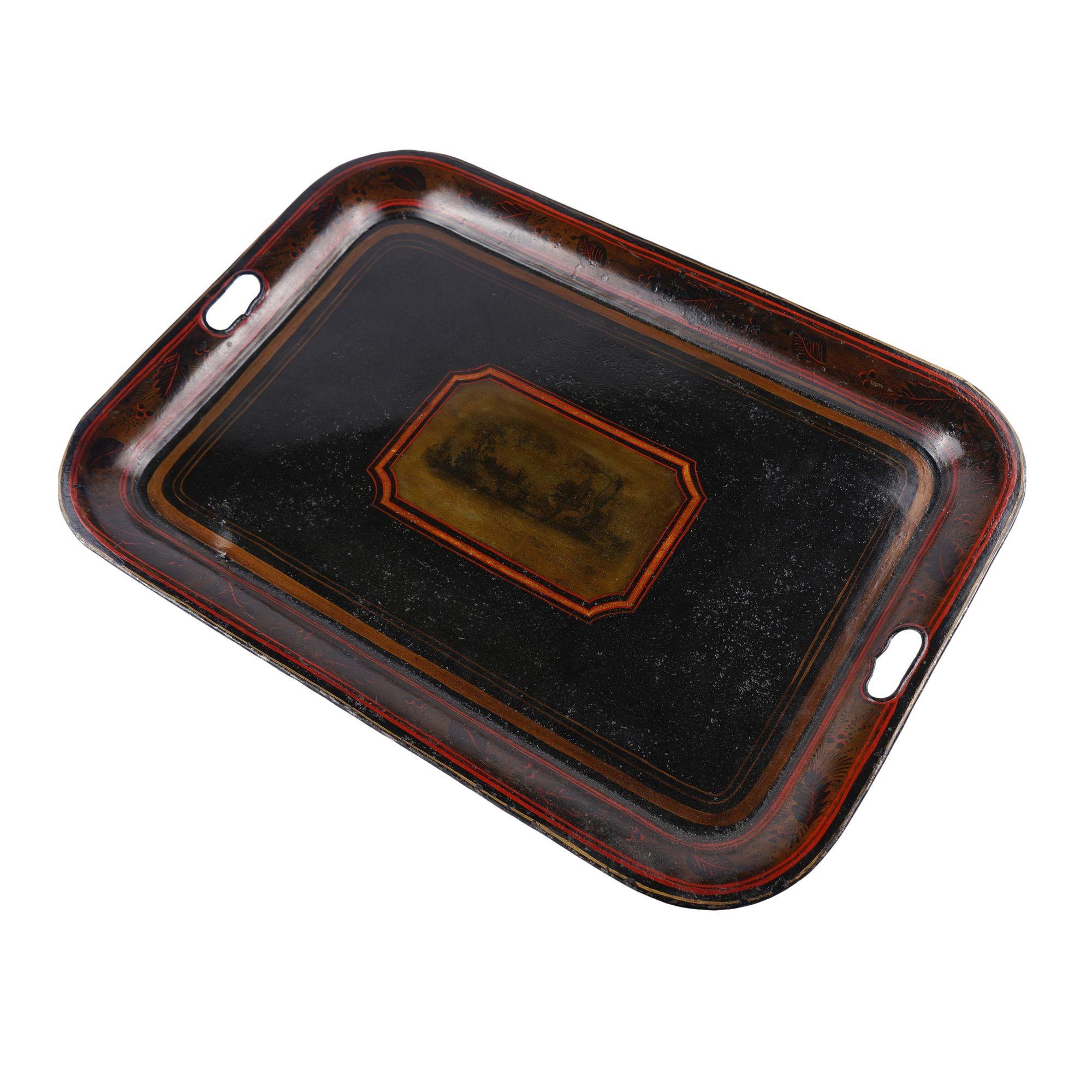 Vassoio da tè in tole con fondo laccato nero con decorazione incentrata su una riserva rettangolare con due donne classicamente drappeggiate in un paesaggio pastorale. Il bordo poco profondo e arrotolato è impreziosito da un bordo stencil di foglie