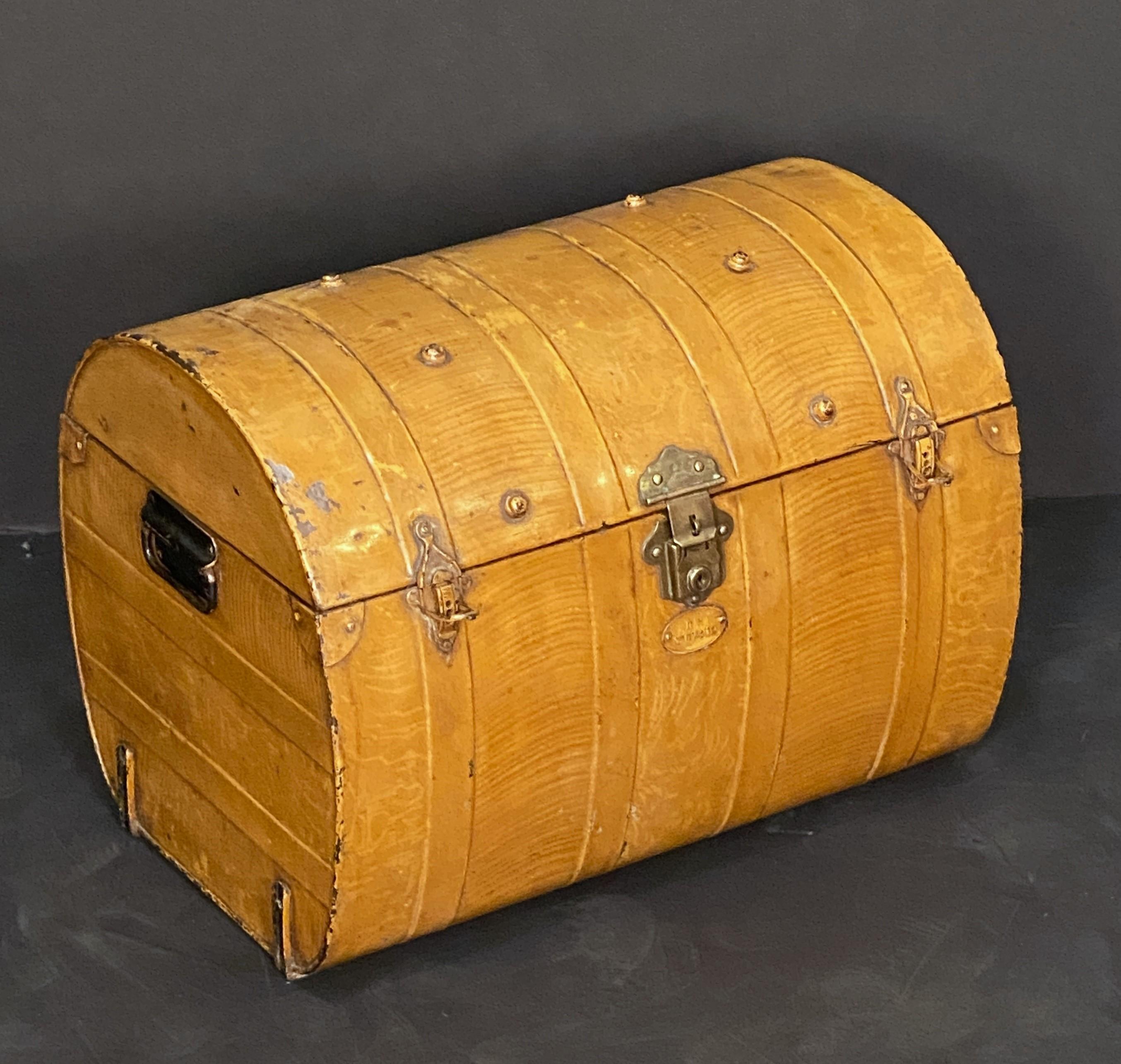 Un bel baule inglese a cupola o da viaggio, risalente al periodo compreso tra il 1858 e il 1880, con corpo in latta smaltata, accenti in testa di chiodo, ferramenta in ottone e maniglie originali in acciaio nero contrapposte. La tradizionale vernice