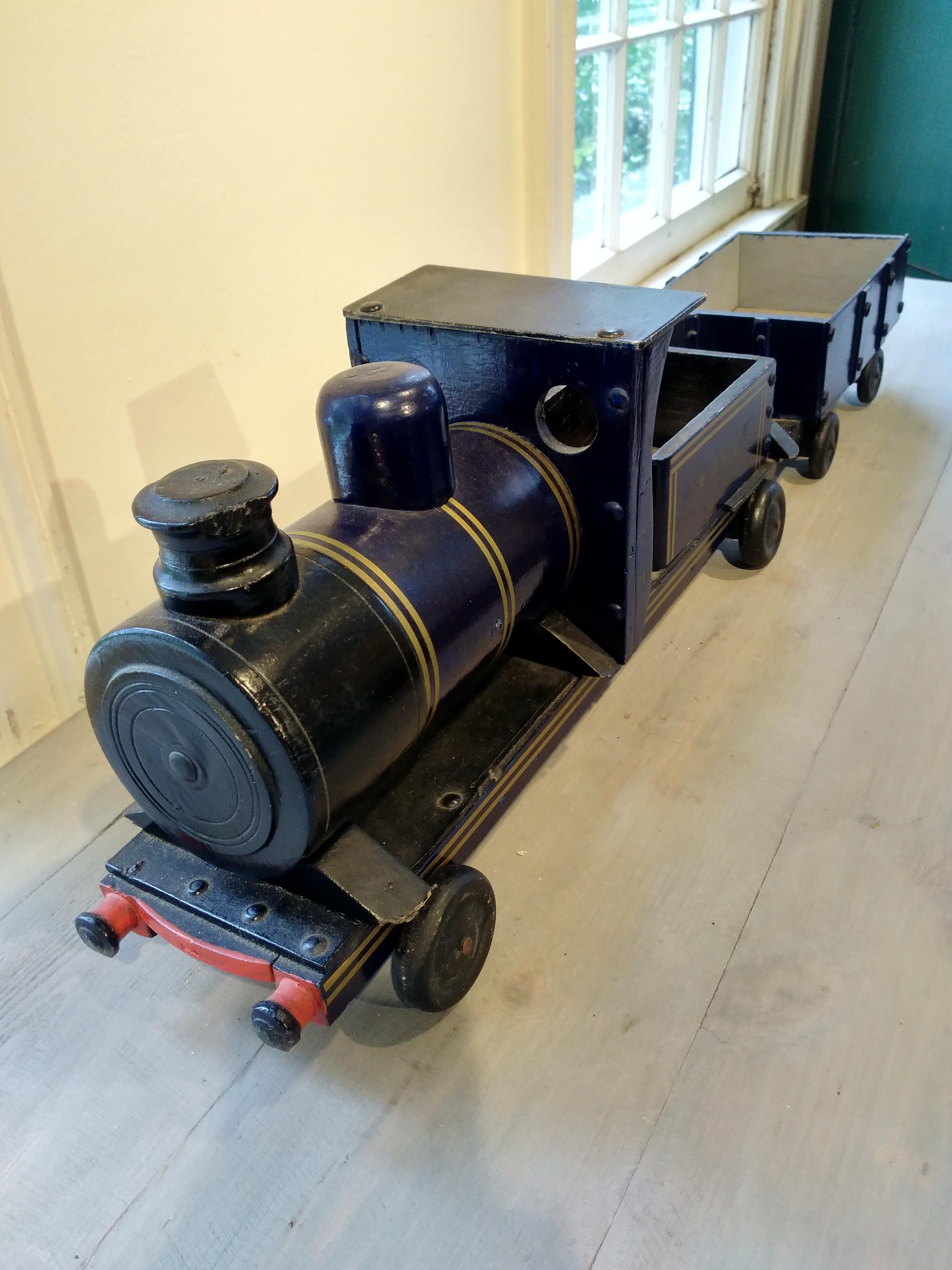A very sweet antique children's toy train from England, 1940. This two-piece set has a locomotive and matching cargo car. It is made of wood and is painted a charming deep blue.
 