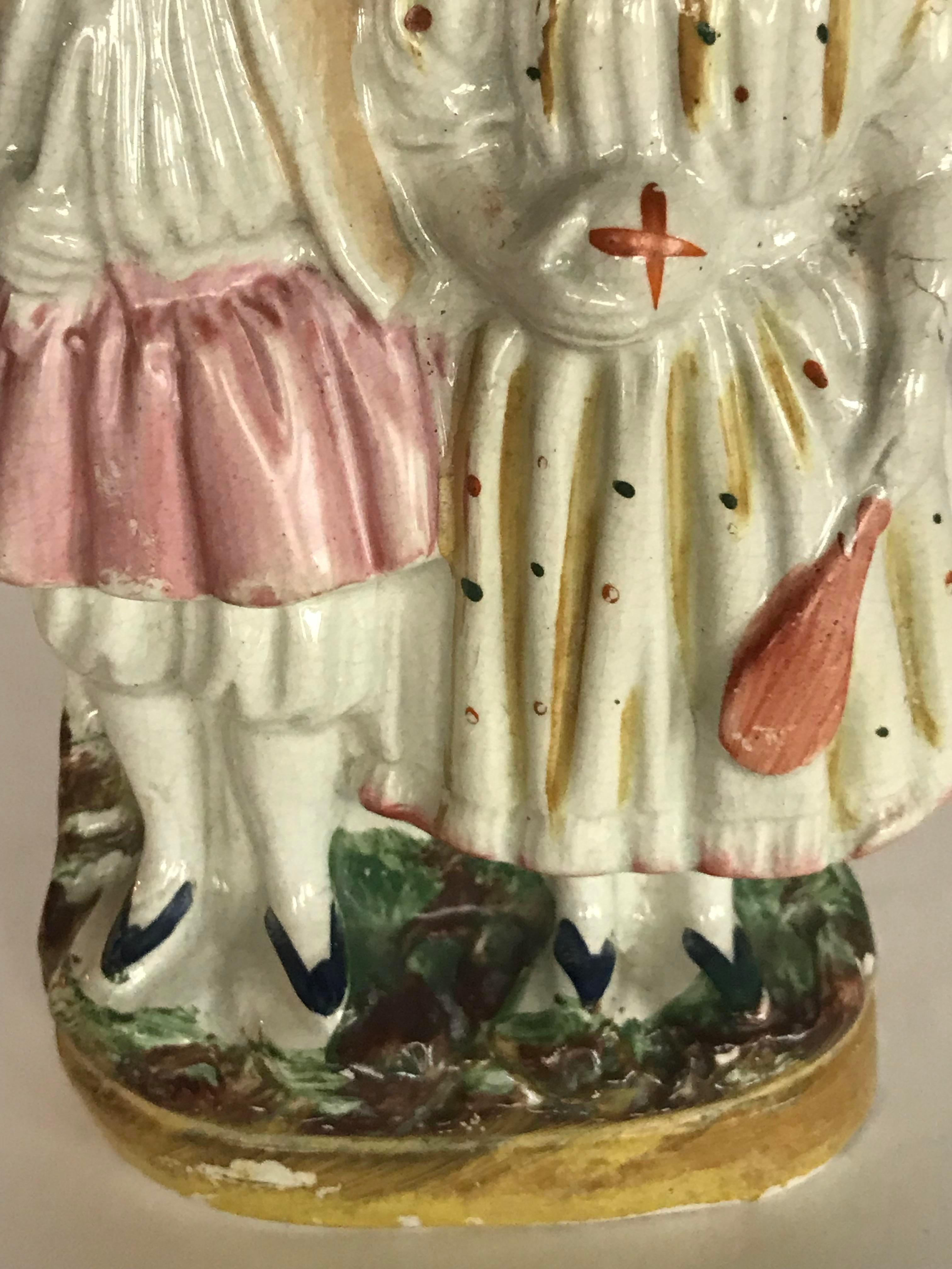 Figurine du Staffordshire représentant 2 personnages. Un bel accent traditionnel ! Un rêve de collectionneur.