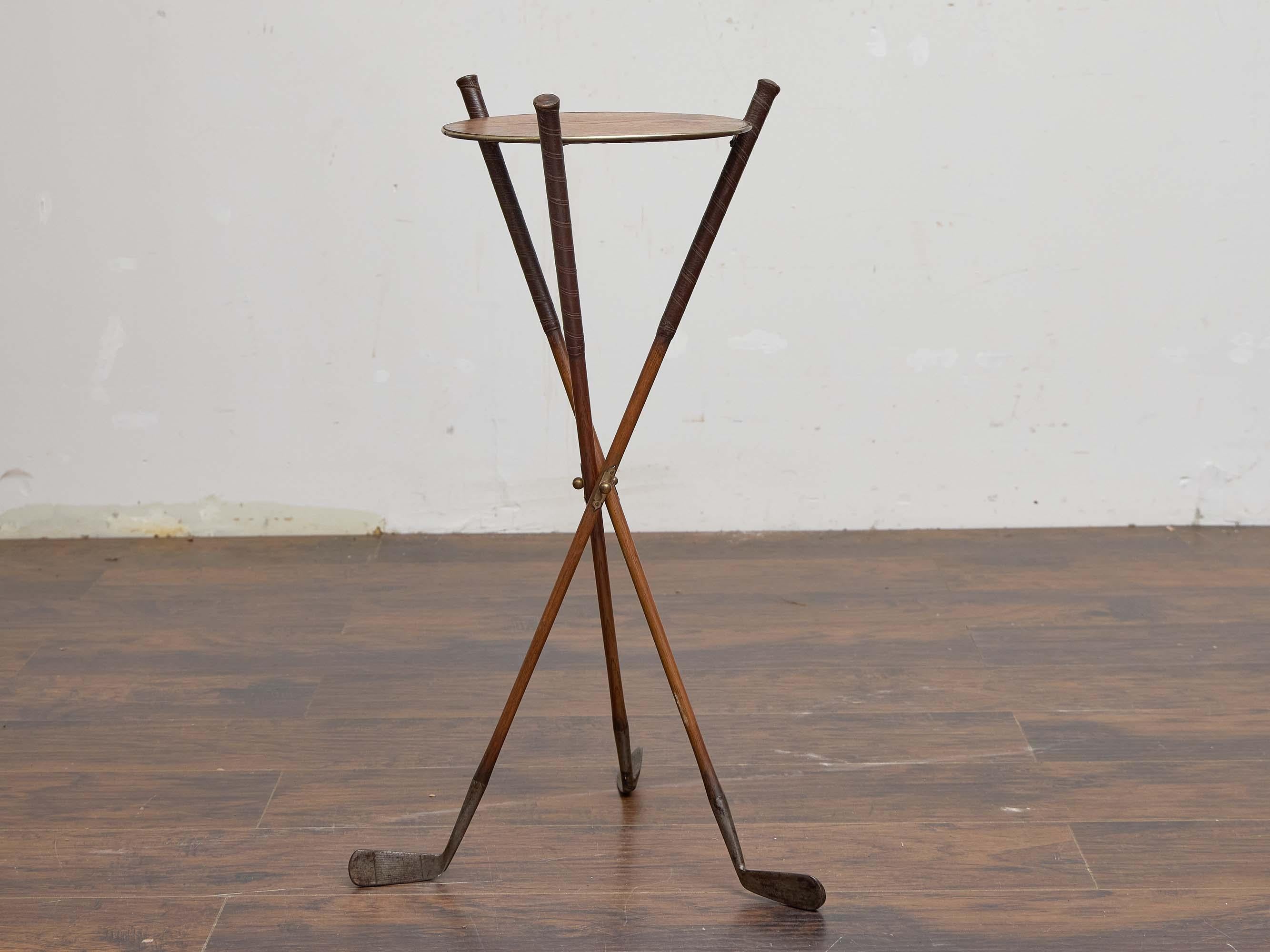 A whimsical and highly collectible side table crafted from vintage golf clubs, dating to the 1920s–1930s. The tripod base is formed from three authentic wooden-shaft clubs, their heads splayed outward to provide stability, while the original leather