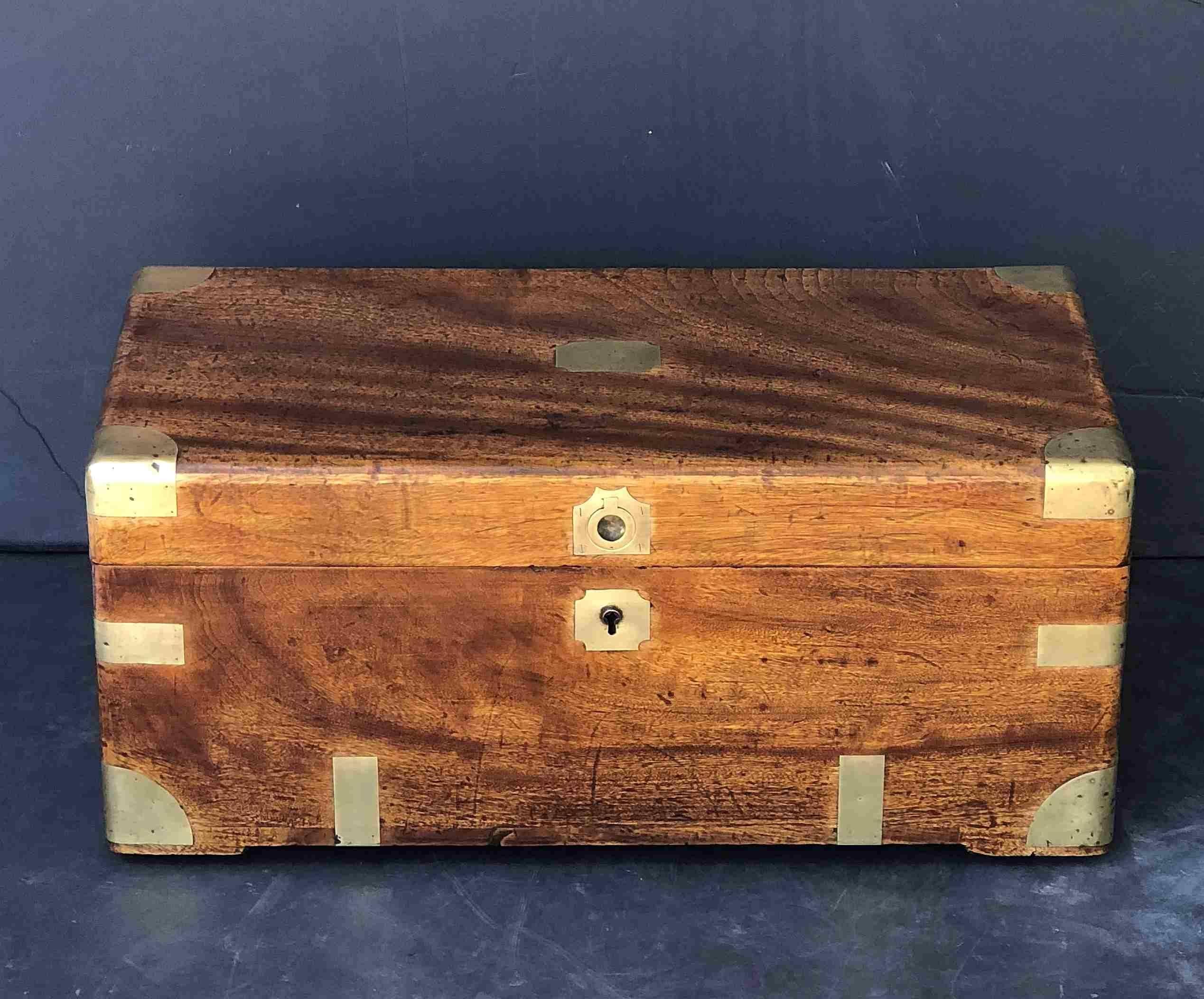 A handsome British military or naval officer's rectangular trunk or chest (coffer) of brass-bound camphor wood, manufactured for an officer to carry his kit on campaign.
With original recessed brass front latch, brass escutcheon, and brass carrying