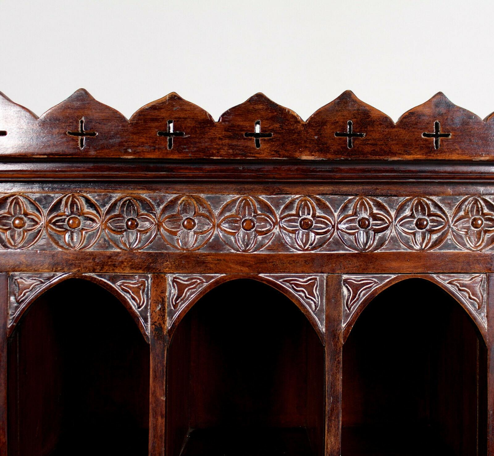 A highly unusual carved hardwood cabinet in the Tudor manner.

An ornately carved deep recesses with arabesque carved corners enclosed shelving and fitted six drawers.