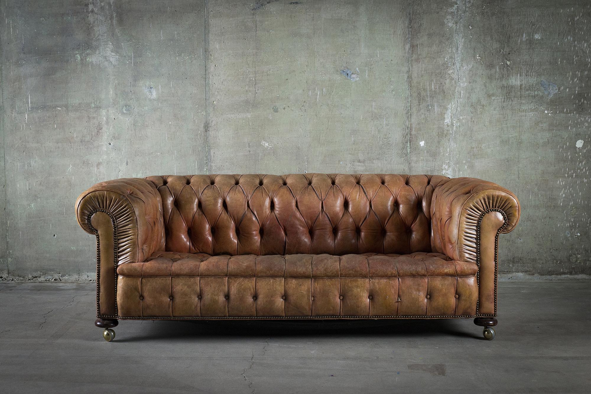 English tufted brown leather sofa with nailhead detail. Wear and use to leather, please see photos.