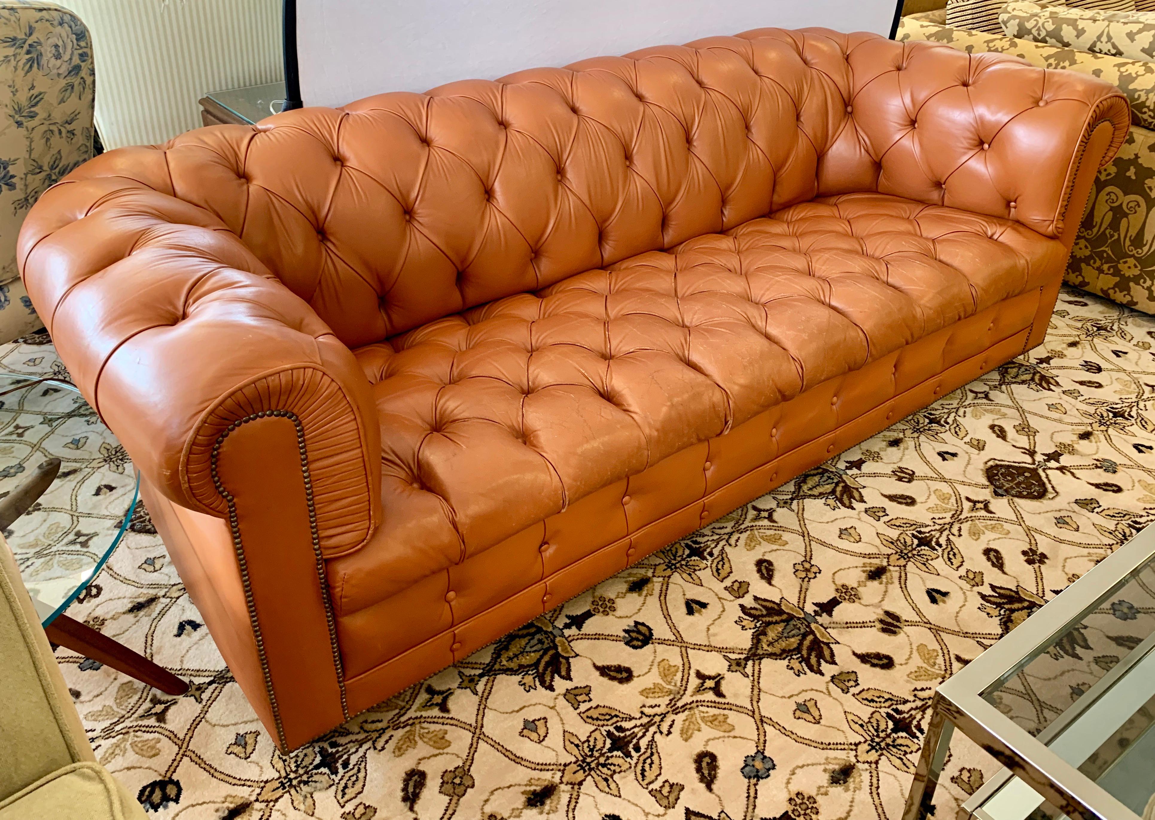 Made in England, Classic chesterfield sofa made with the finest soft and supple leather. This is the larger
version that fits three people comfortably, circa 1970s with leather that has been broken in well.