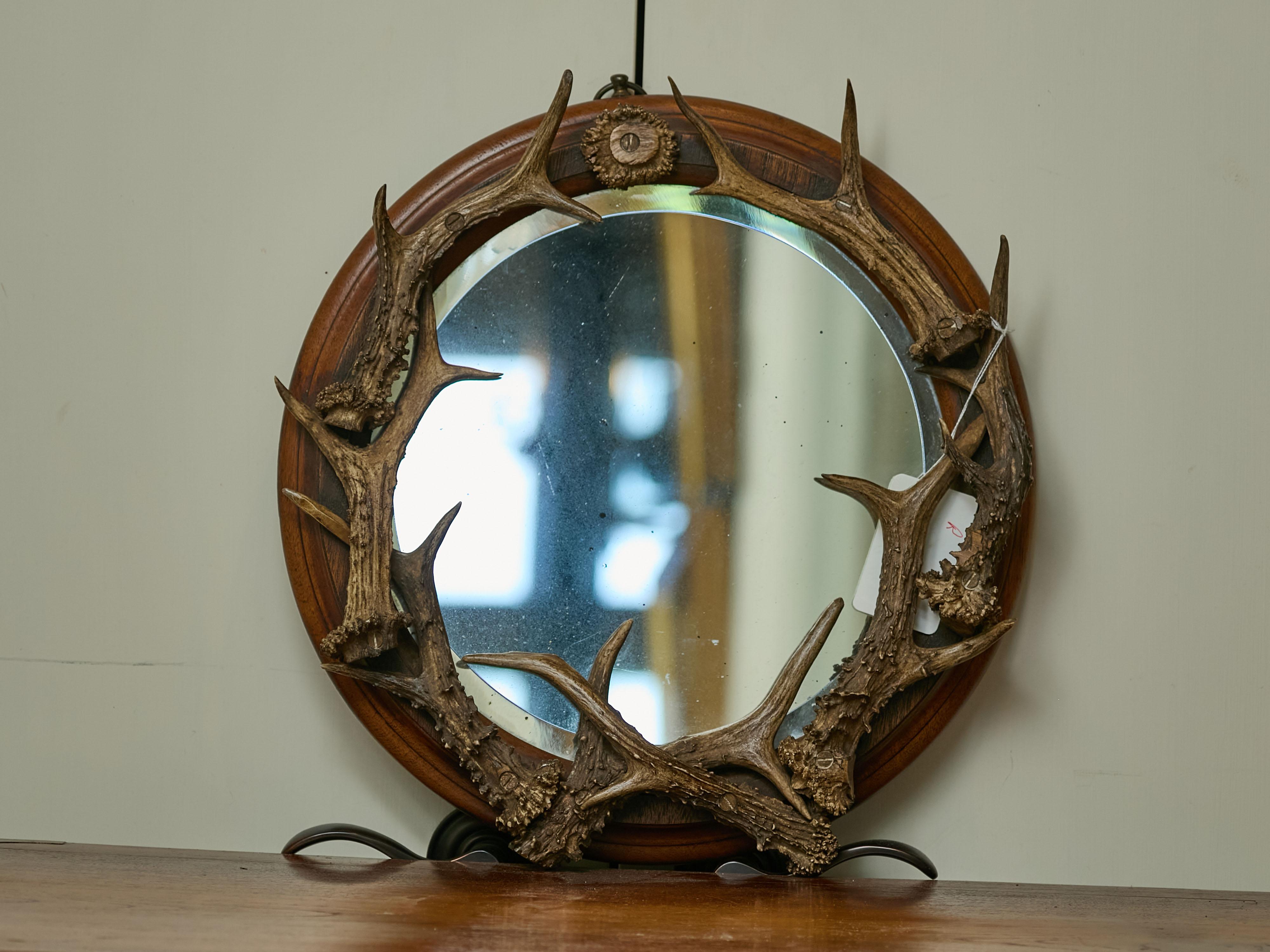 Miroir circulaire en bois de cerf, avec cadre en bois, datant du début du siècle, vers 1900. Ce miroir circulaire en bois de cerf du début du siècle attire l'attention par son charme rustique et son design unique. Le cadre circulaire robuste en bois