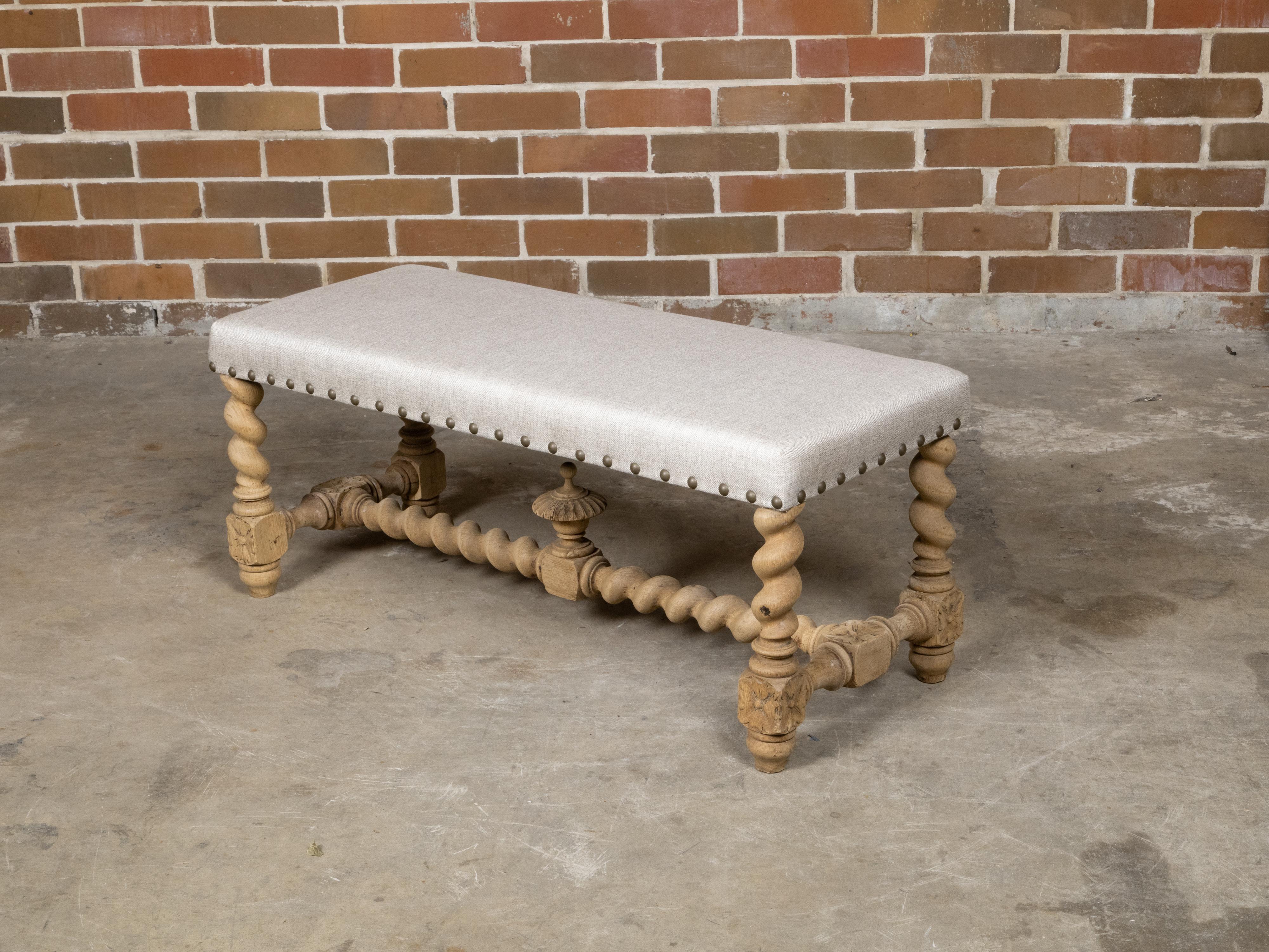 An English Turn of the Century bleached wood bench from circa 1900 with barley twist base and custom upholstery. This exquisite English Turn of the Century bleached wood bench from circa 1900 exudes a timeless elegance and masterful craftsmanship.