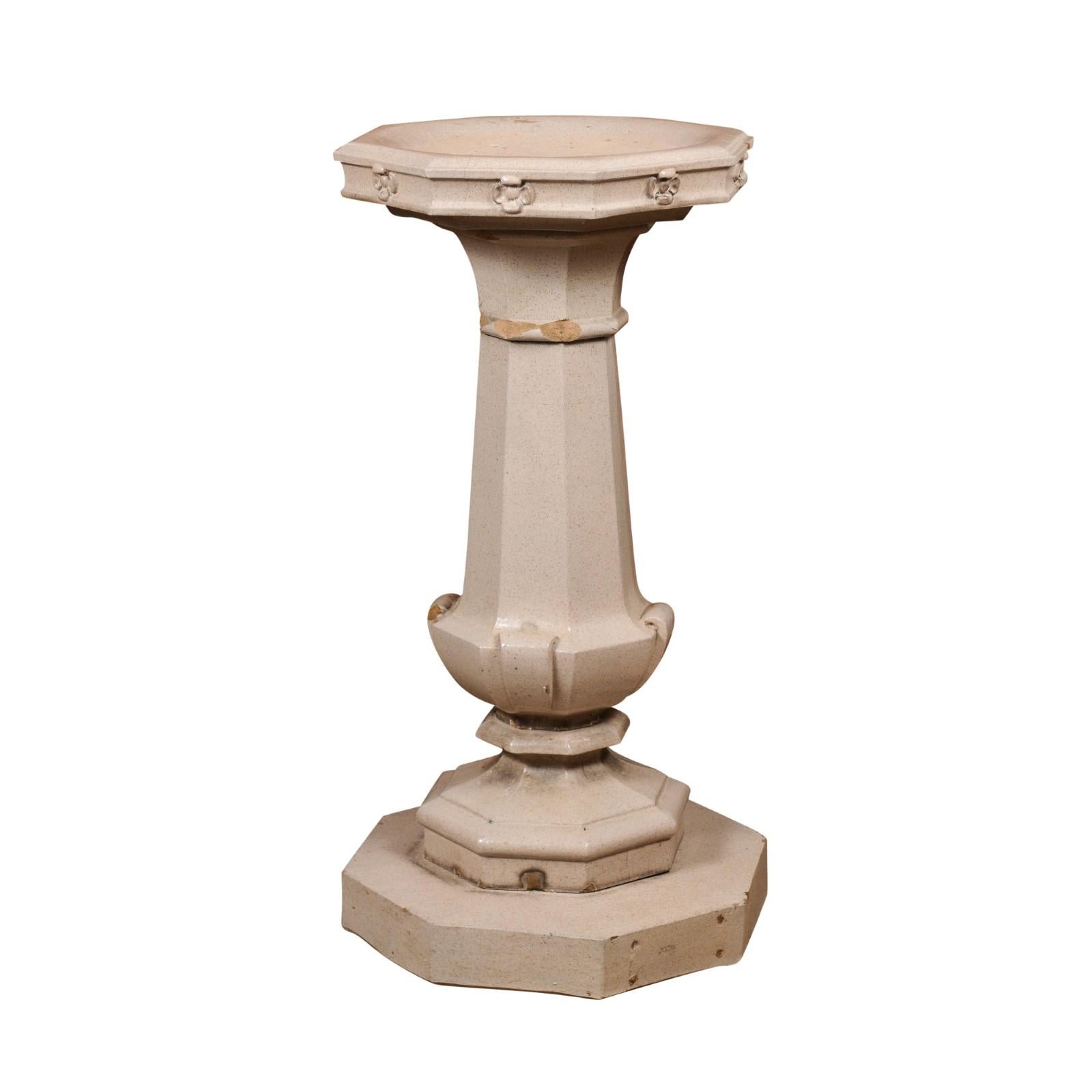 An English turn of the century glazed pottery bird bath from the early 20th century, with octagonal top, carved flowers, tapered pedestal and stepped base. Created in England at the Turn of the Century which saw the transition between the 19th to