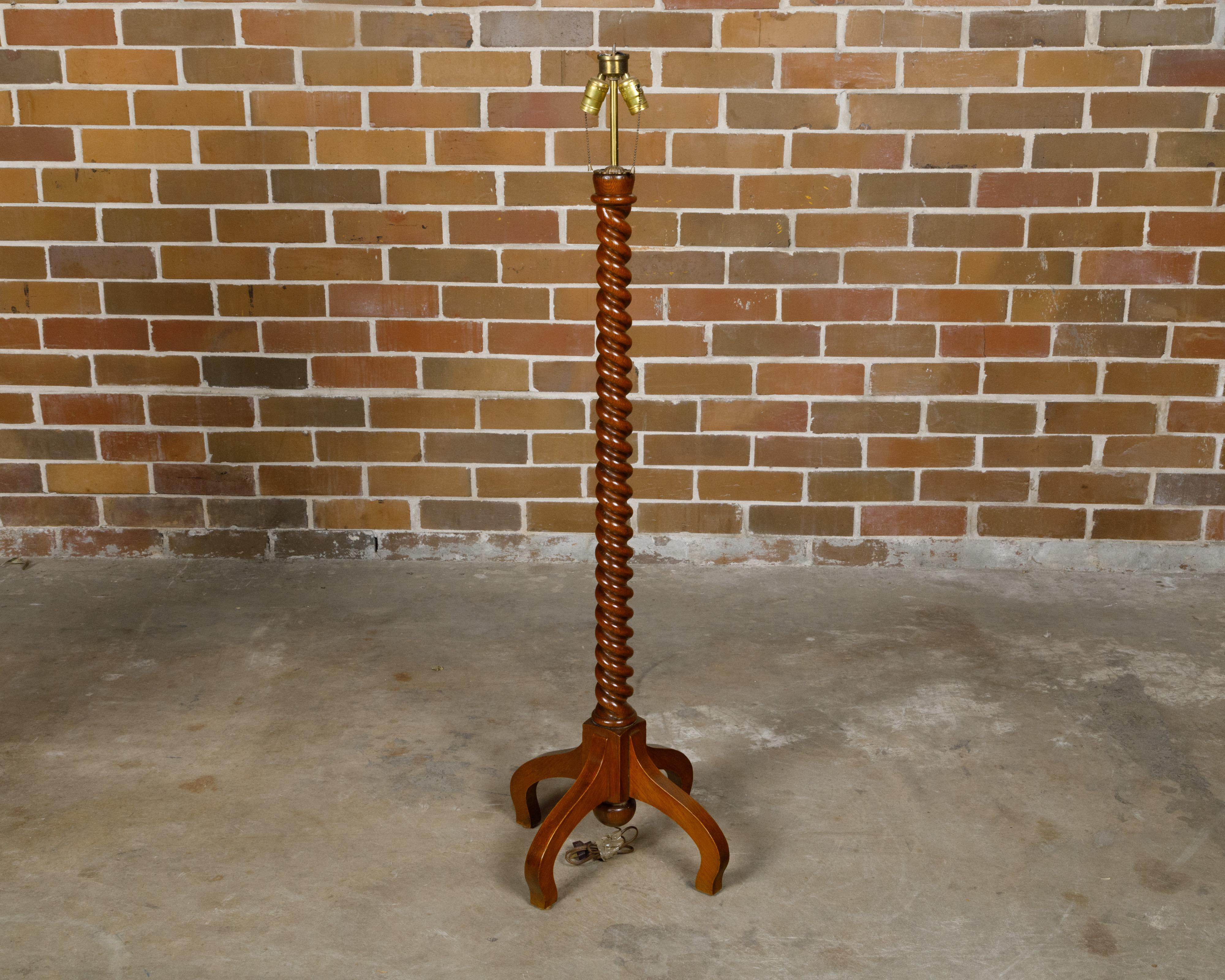 Lampada da terra inglese di fine secolo in quercia del 1900 circa con piedistallo a torsione d'orzo e base a quadripode. Questa lampada da terra in quercia inglese di fine secolo, risalente al 1900 circa, cattura senza sforzo il fascino dell'epoca