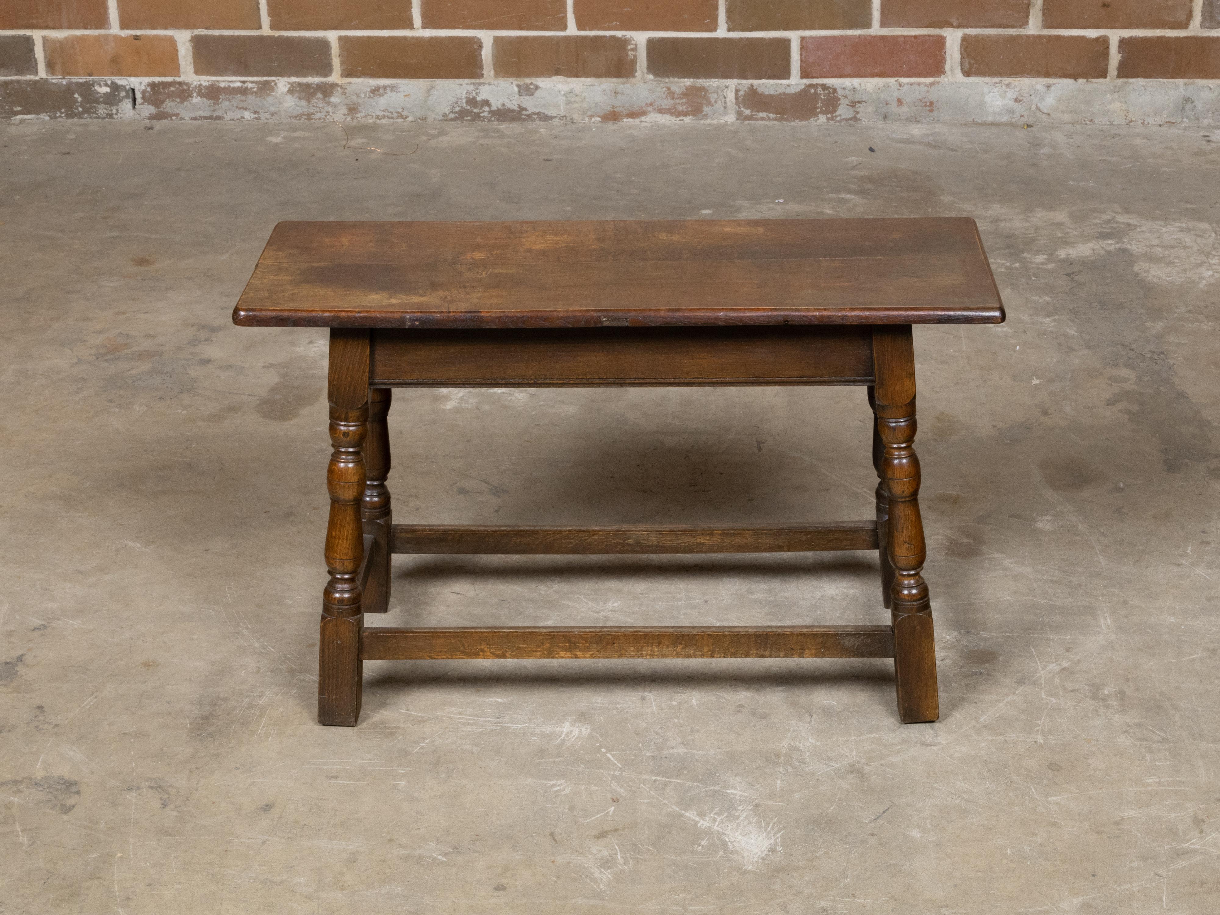 Sgabello inglese di fine secolo in quercia del 1900 circa, con gambe a balaustro tornite e barelle laterali. Questo sgabello inglese di fine secolo in quercia, risalente al 1900 circa, emana un affascinante carattere rustico, esaltato dalla sua