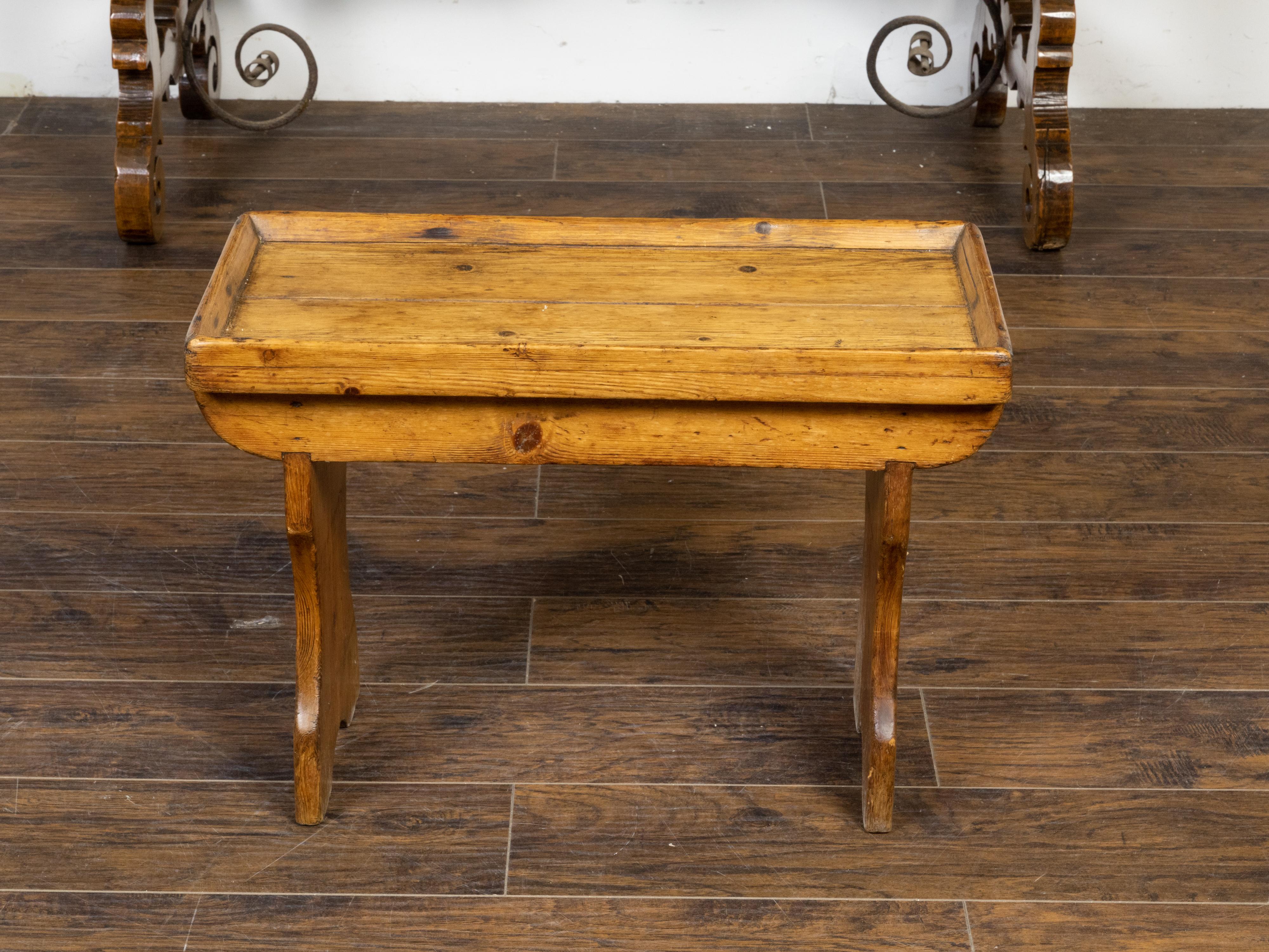 An English Turn of the Century pine drinks table from circa 1900 with small tray top, carved legs and nice rustic character. Immerse yourself in the charm and warmth of early 20th-century English design with this Turn of the Century pine drinks