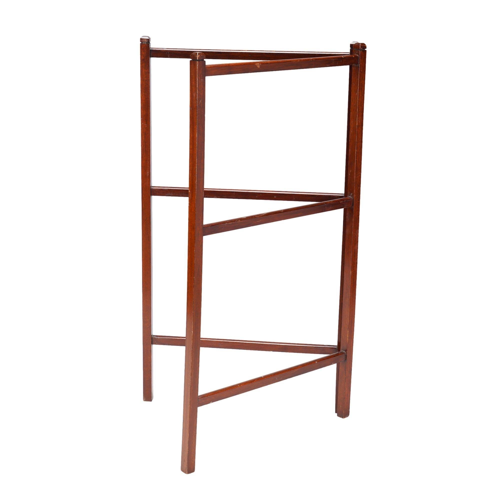 Hinged, two part mahogany three tier towel rail. The rails and uprights are square cut and morticed together. The two sections are joined with three brass hinges.

England, circa 1890-1910.

Dimensions: 32-1/2