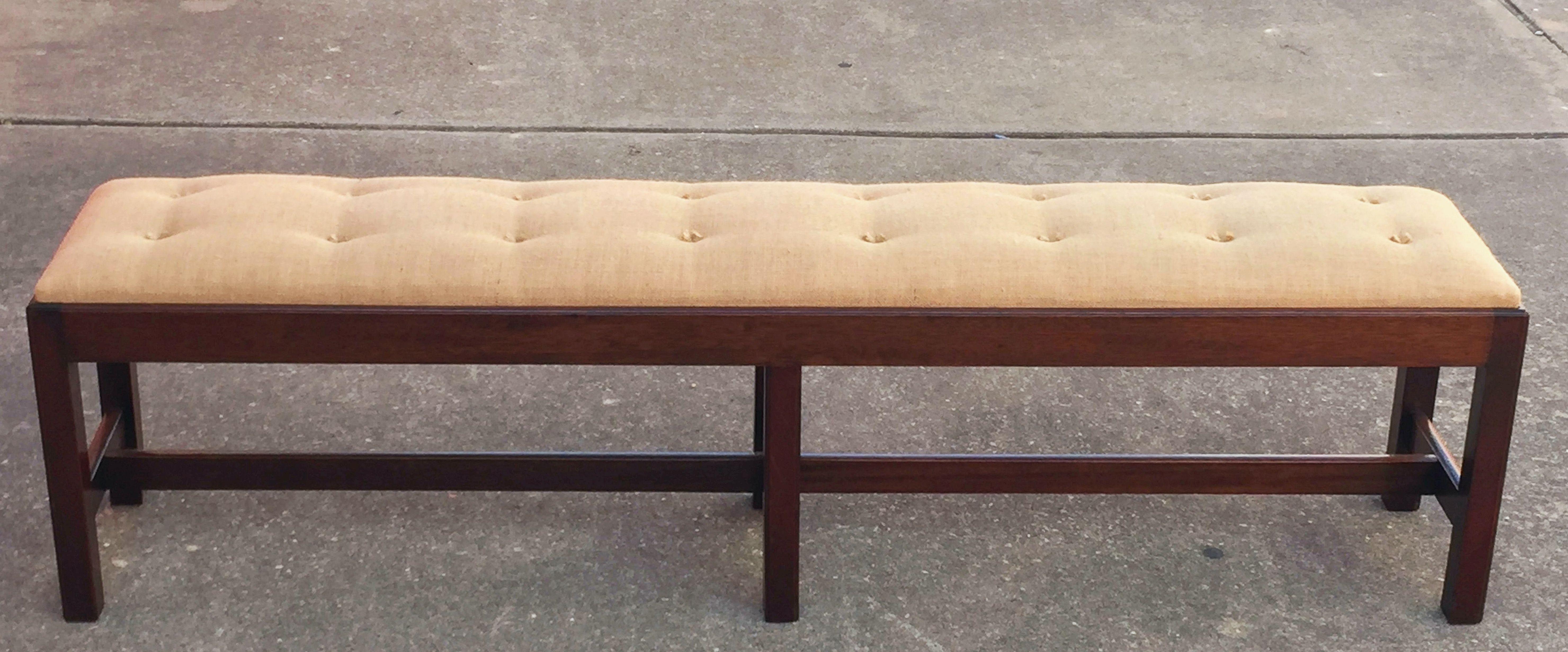 A fine English upholstered long bench or seat of mahogany, in the Chippendale style, featuring a rectangular tufted cushion top over a stretcher base on six canted legs.

DIMENSIONS:  H 19 in. x W 71.5 in. x D 14 in.