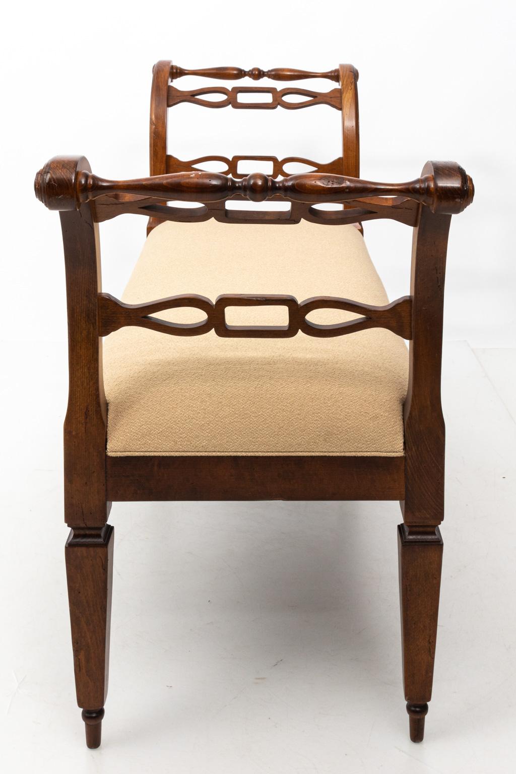 English upholstered window bench with scrolled arms and turned legs. Please note of wear consistent including minor finish loss and minor evidence of woodworm.