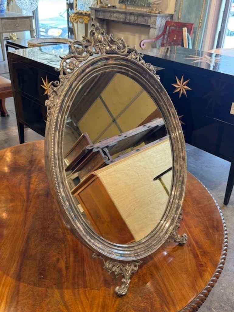 Fine quality 19th century English silver and bronze vanity mirror. English silver and bronze vanity mirrors are prized for their elegant materials, intricate detailing, and timeless appeal. Circa 1870. 17.5w x 26h