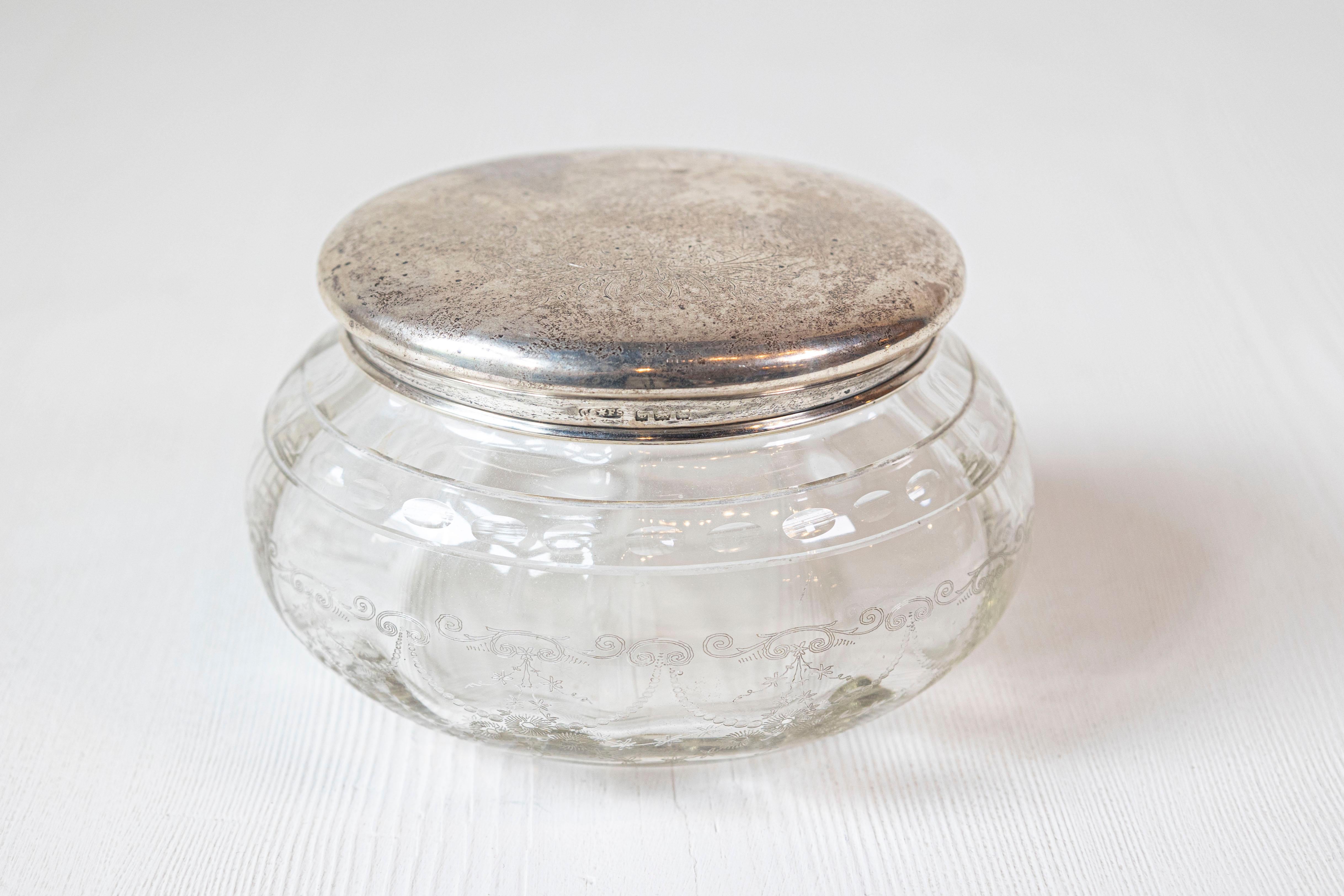 Piccolo vaso da vanità in vetro di epoca vittoriana inglese del XIX secolo, con coperchio in argento inciso e disegno inciso. Creato in Inghilterra durante il regno della Regina Vittoria, questo piccolo vaso presenta un corpo circolare in vetro
