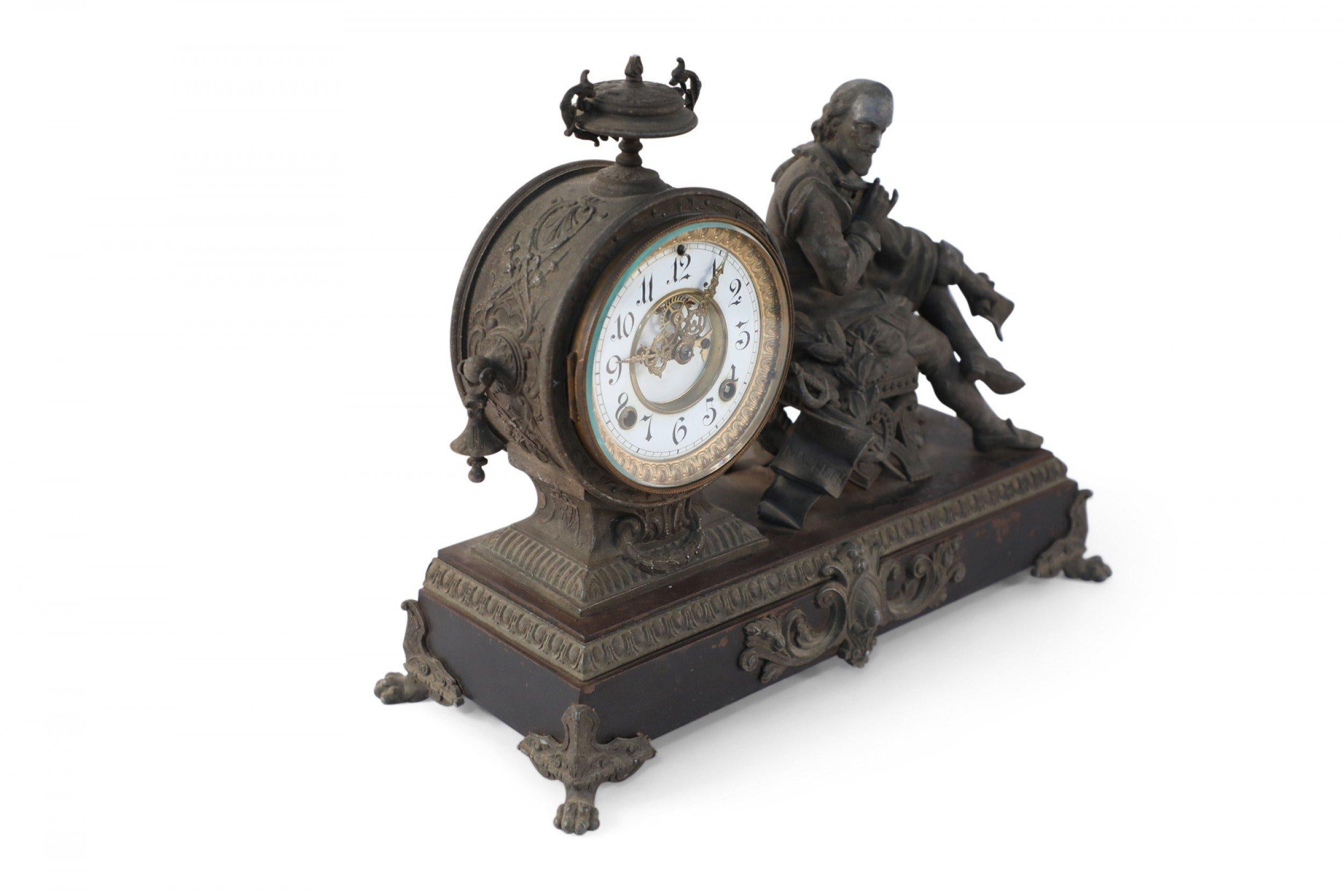 English Victorian Ansonia figural bronze Shakespeare mantel clock featuring the figure of Shakespeare seating next to a white and gilt circular clockface with quil and paper in hand flanked by a sword on a rectangular footed base. (ANSONIA CLOCK