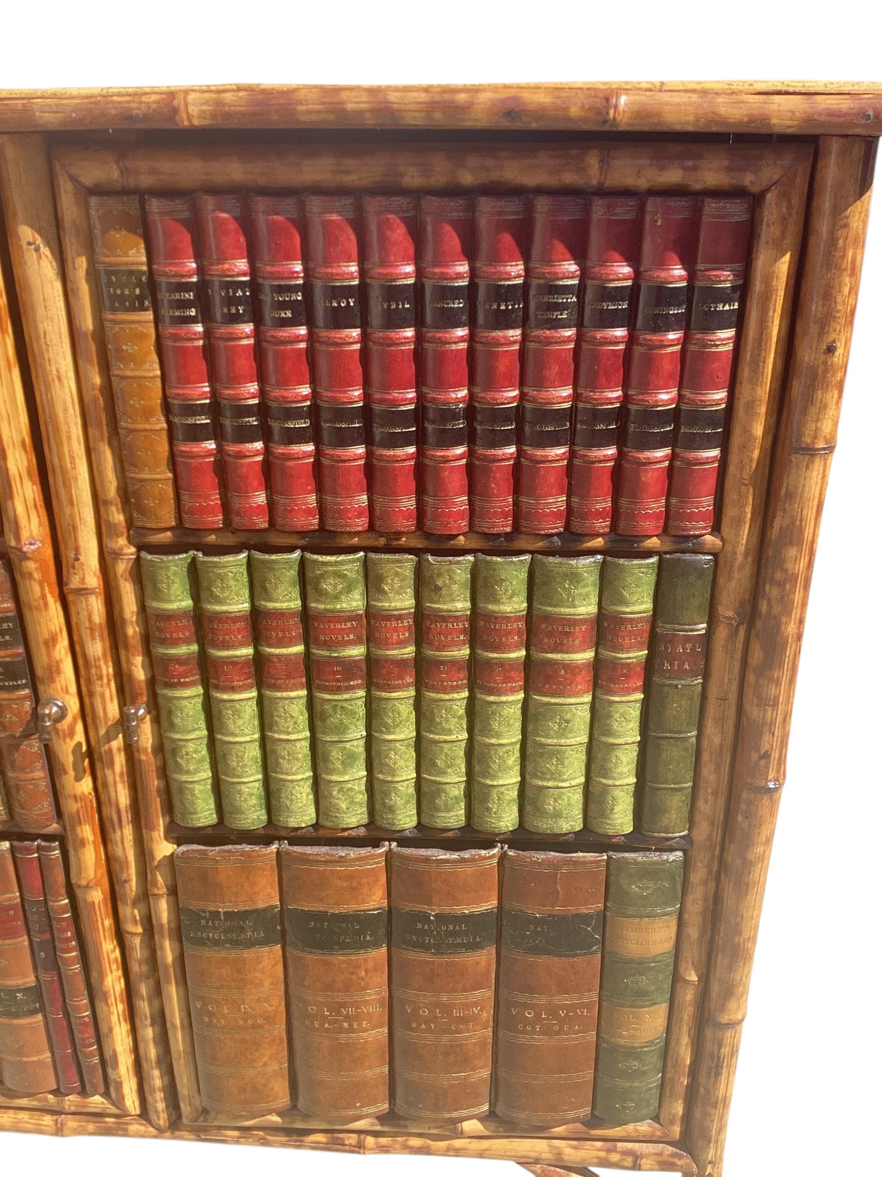 Libreria vittoriana inglese in bambù con ante rilegate. Le doppie porte sono incorniciate da rilegature del XIX secolo e si aprono per rivelare una struttura a due ripiani. È un'ottima aggiunta a qualsiasi ambiente.