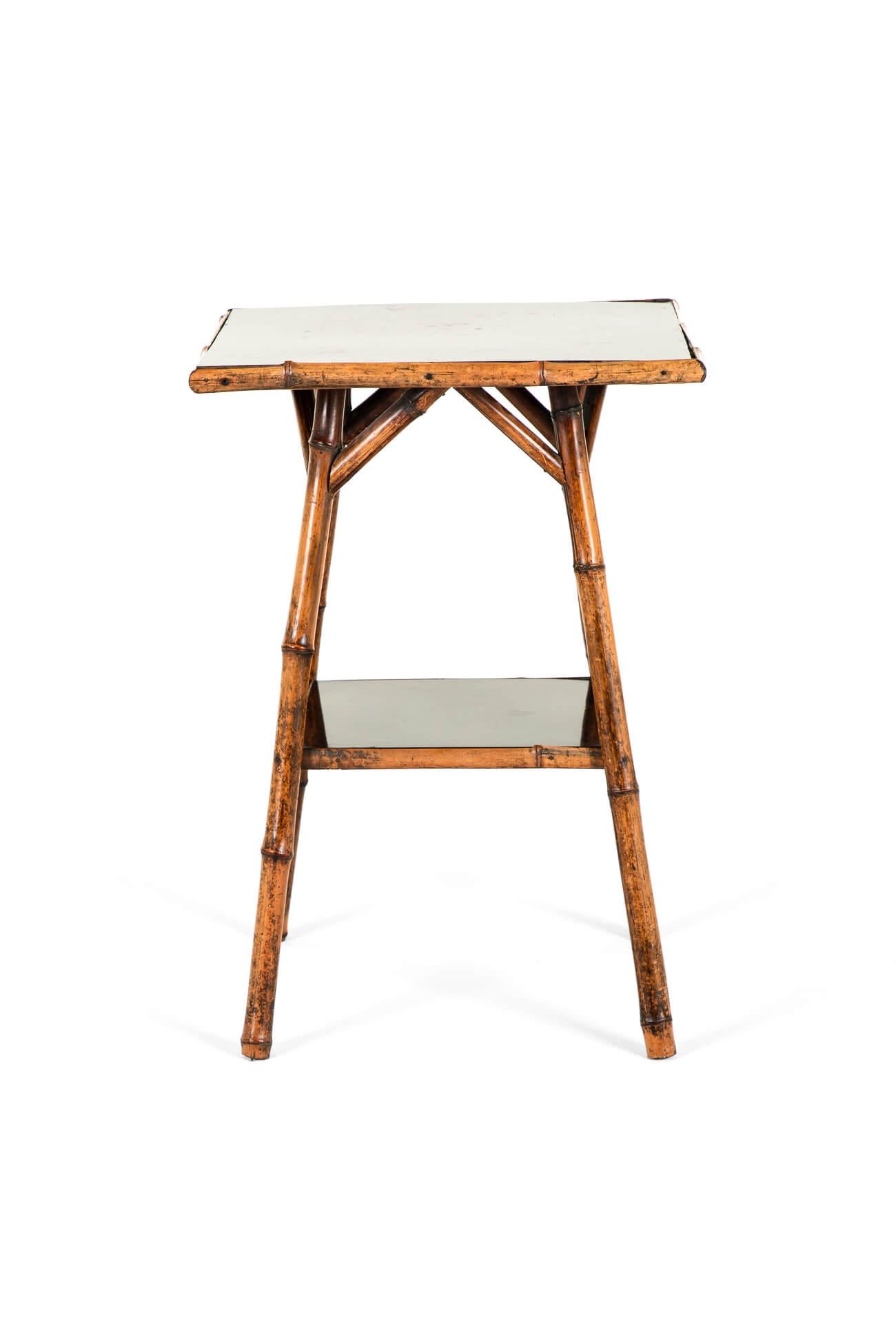 A Victorian bamboo side table with two lacquer work tiers on splayed legs with triangular supports.

Strong and sturdy and ready to serve for another hundred years.

English, circa 1895.

TOTAL

W: 44.5 CM  W: 17.5 INCHES

D: 45.5 CM  D: 17.9