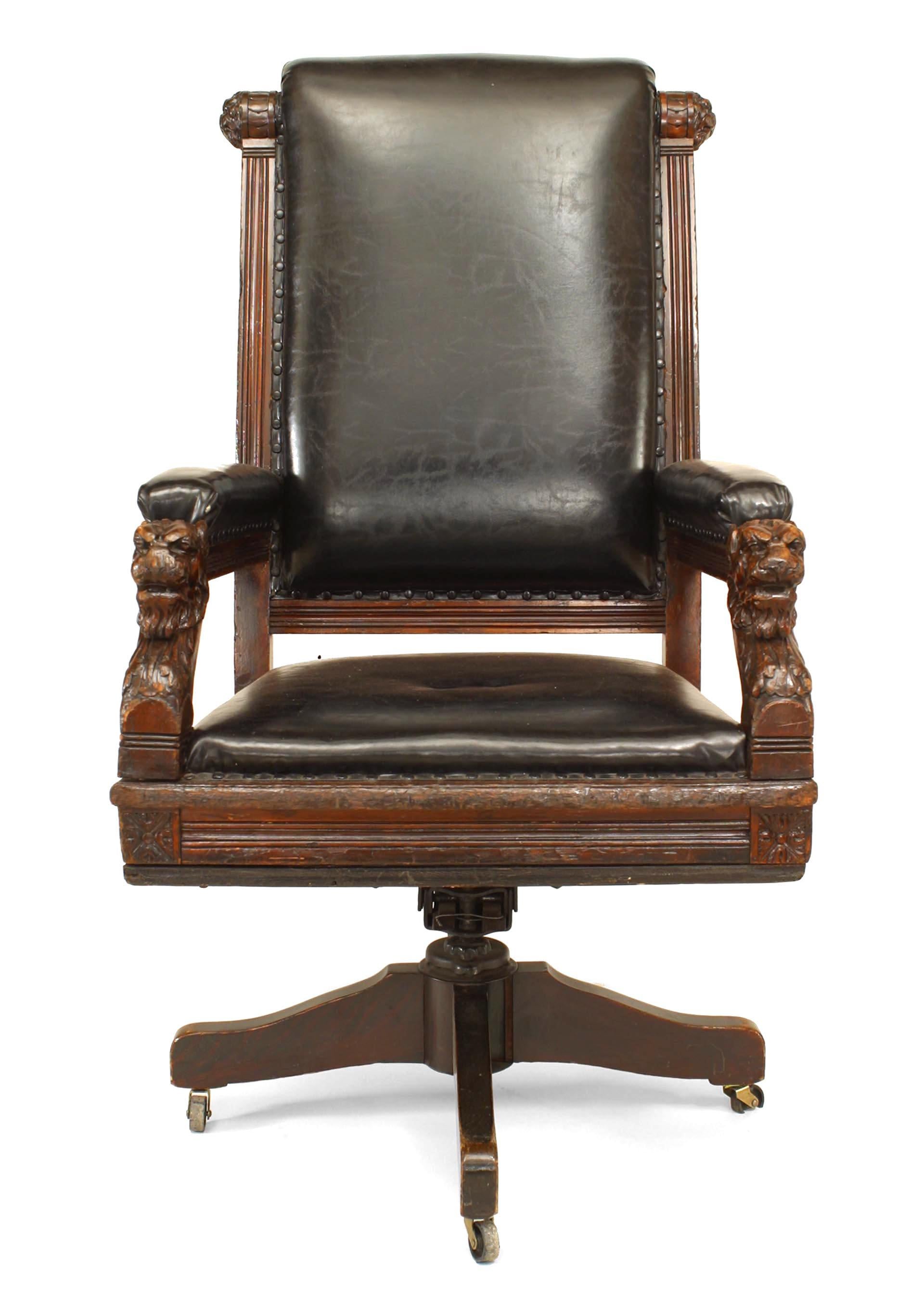 English Victorian high back black leather judge's swivel chair with carved lion heads on arms.