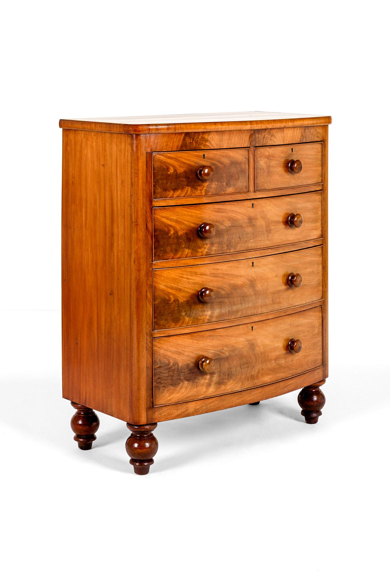 A grand mahogany bow fronted chest of drawers with an arrangement of two short over three long graduating drawers.

The cockbeeded oak lined drawers run smoothly and exhibit the original brass escutcheons and turned handles to each.

United by a