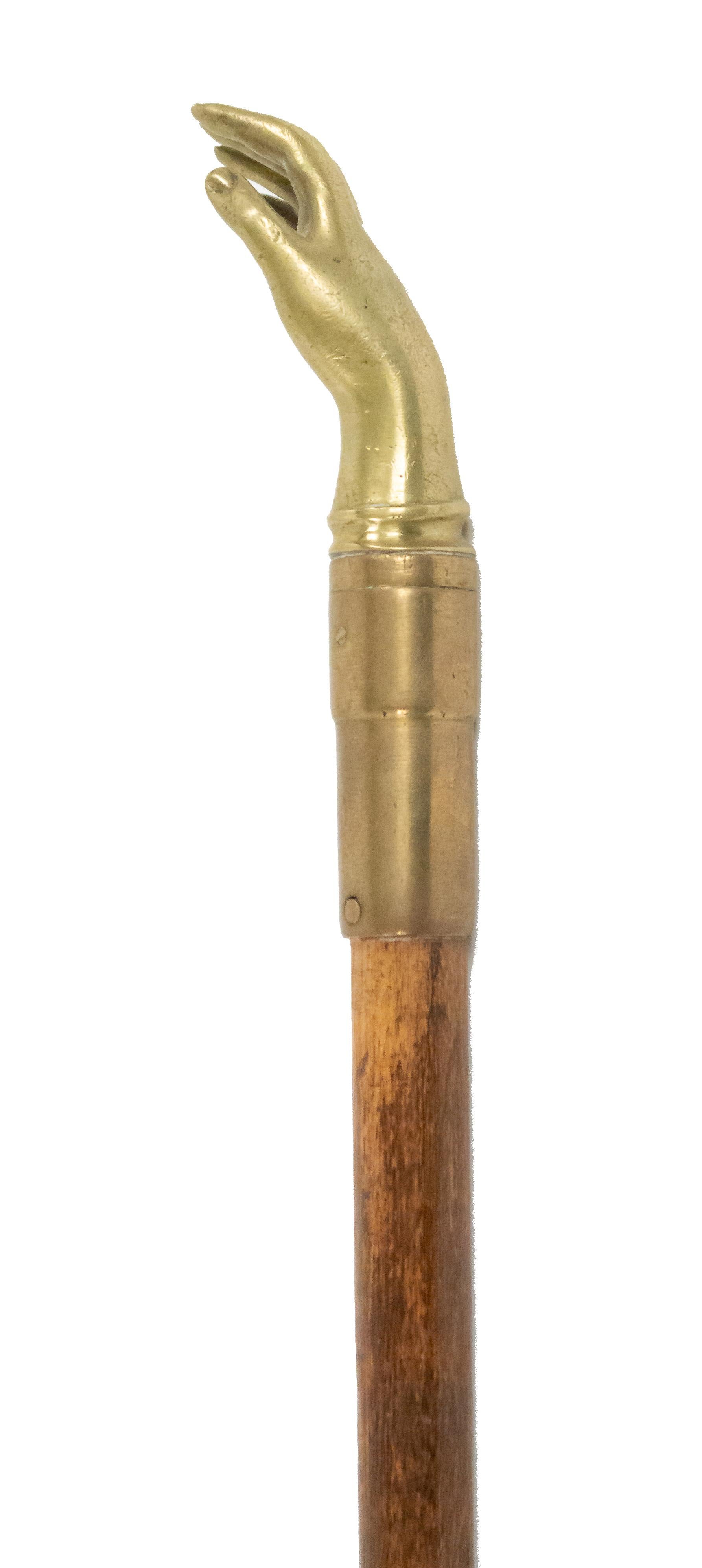 Bastone vittoriano inglese in legno con manico in ottone a forma di mano aperta.
 