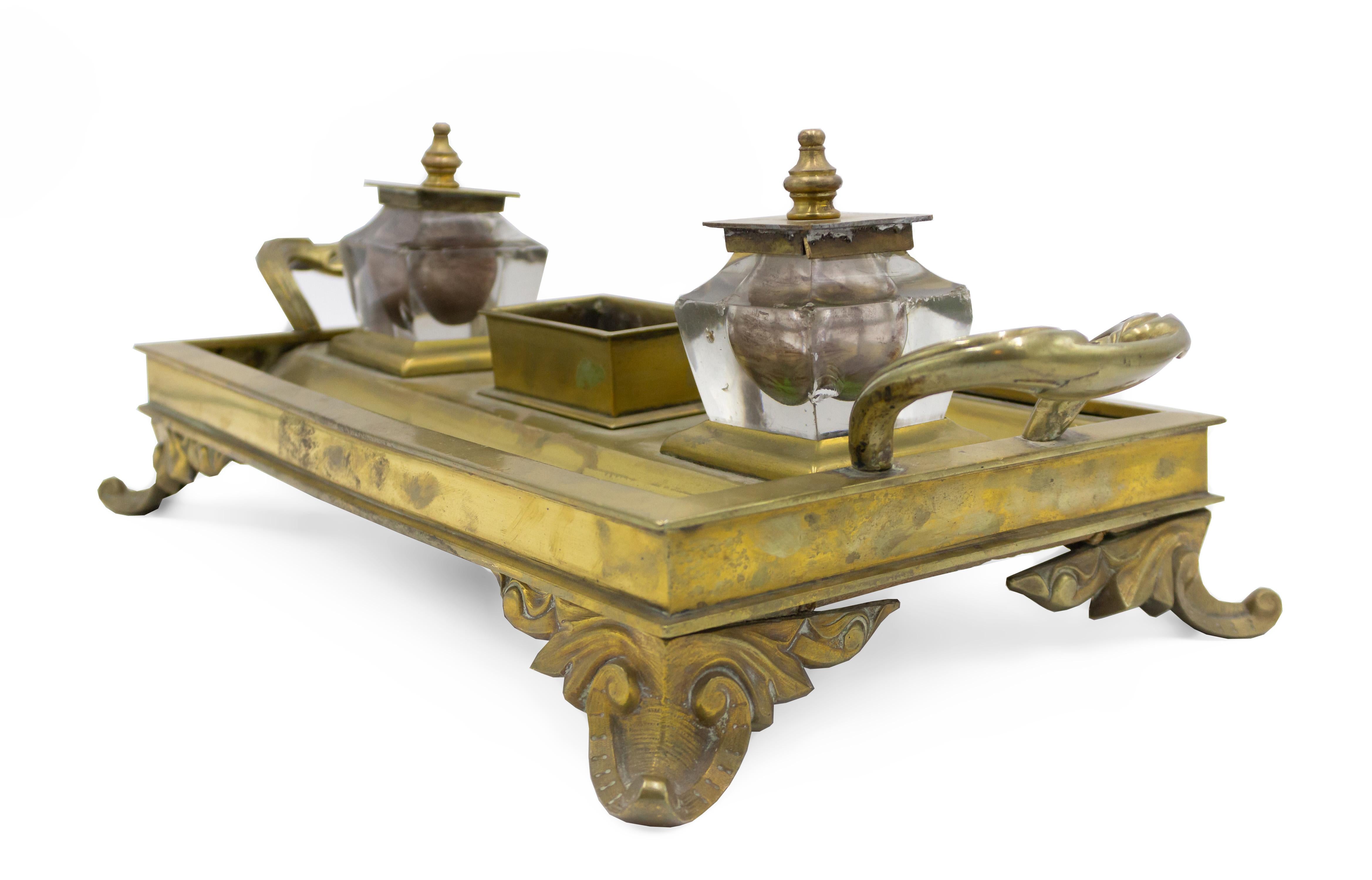 English Victorian bronze inkwell with 2 crystal wells with finial tops and side handles on 4 scroll legs.
 