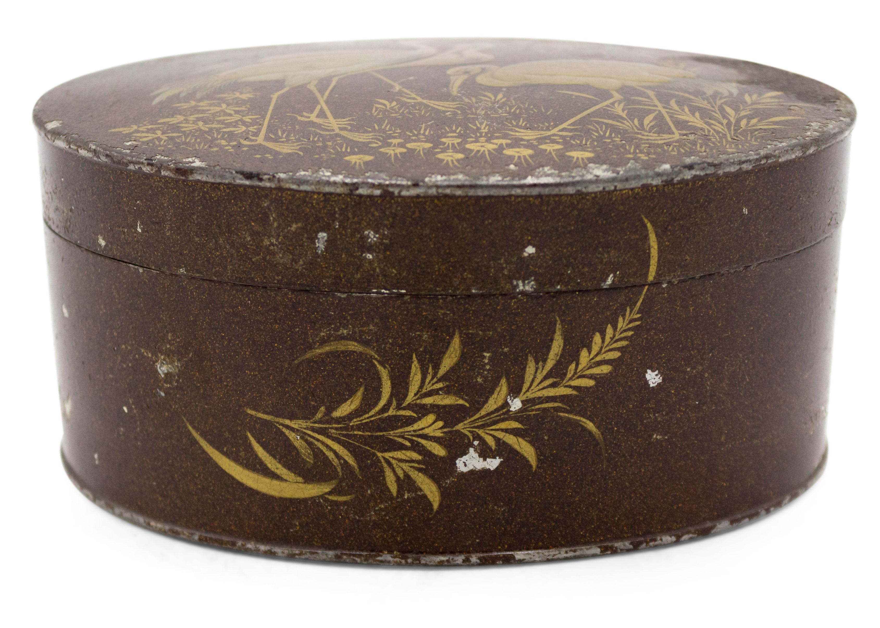 English Victorian brown lacquered tole oval shaped box with three herons on top.
 