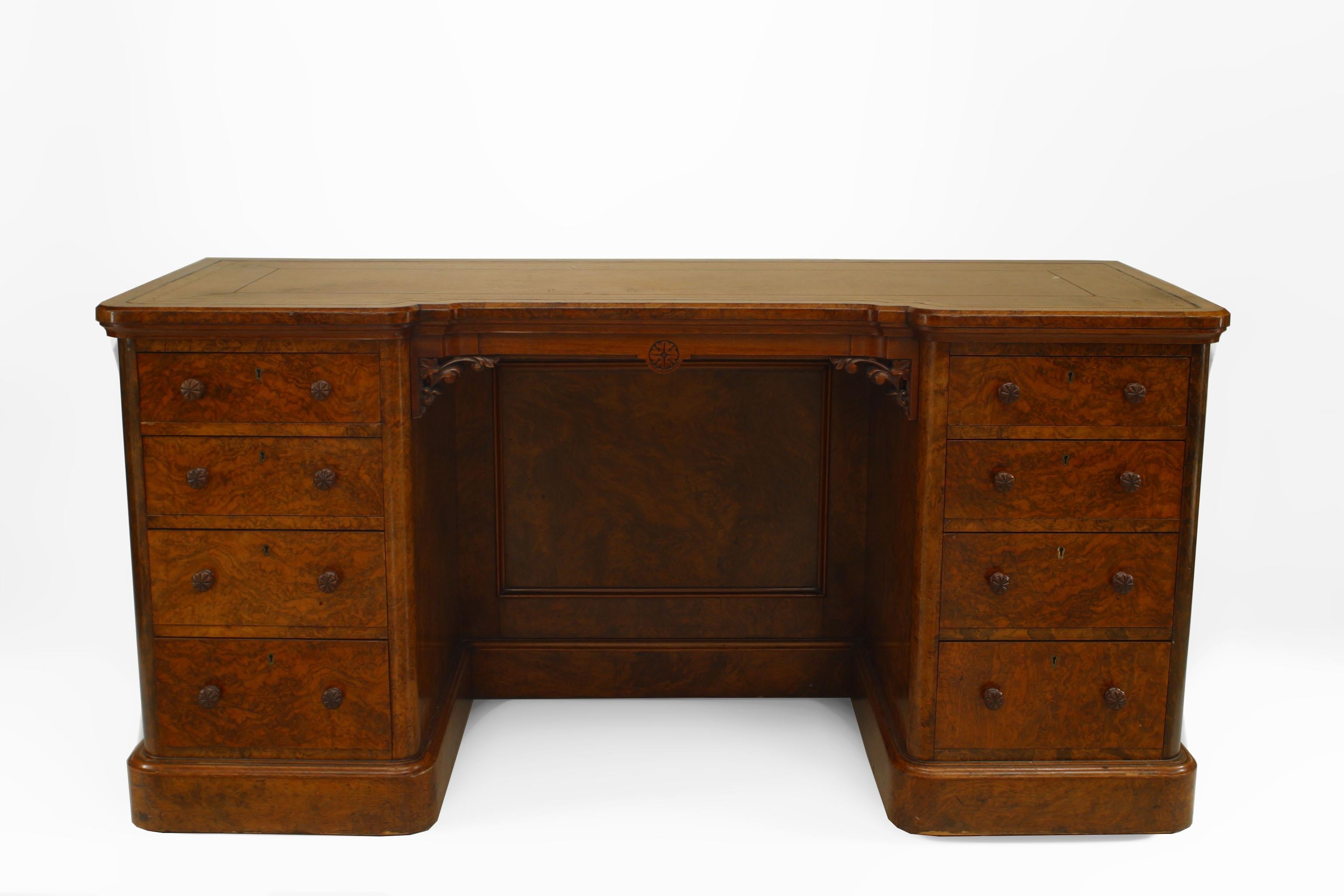 English Victorian burl walnut double pedestal kneehole desk with 8 drawers and a vanity panel center with a brown leather top having a gold tooled border.

