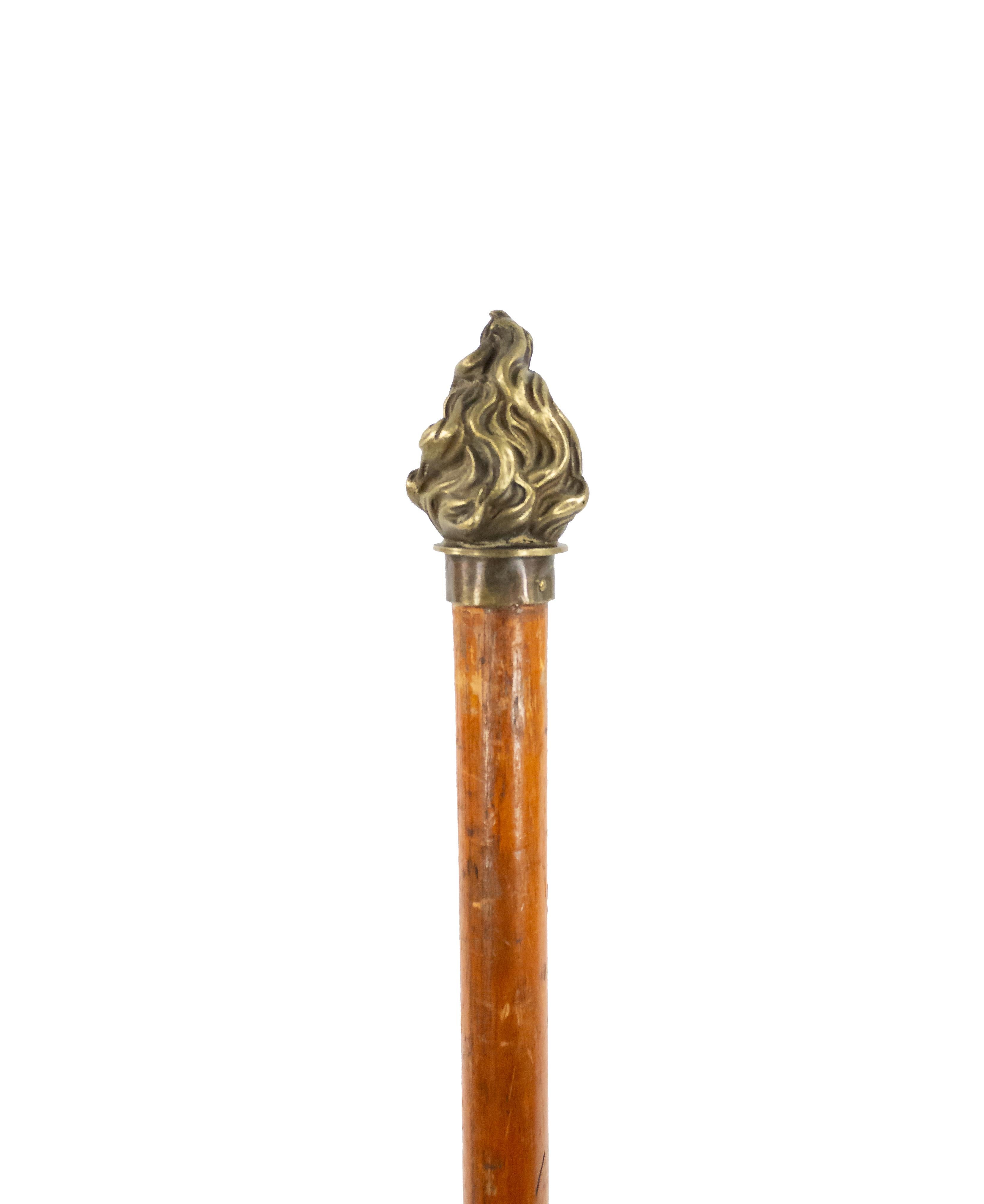 English Victorian light oak walking cane with bronze flame form handle and brass tip.
 