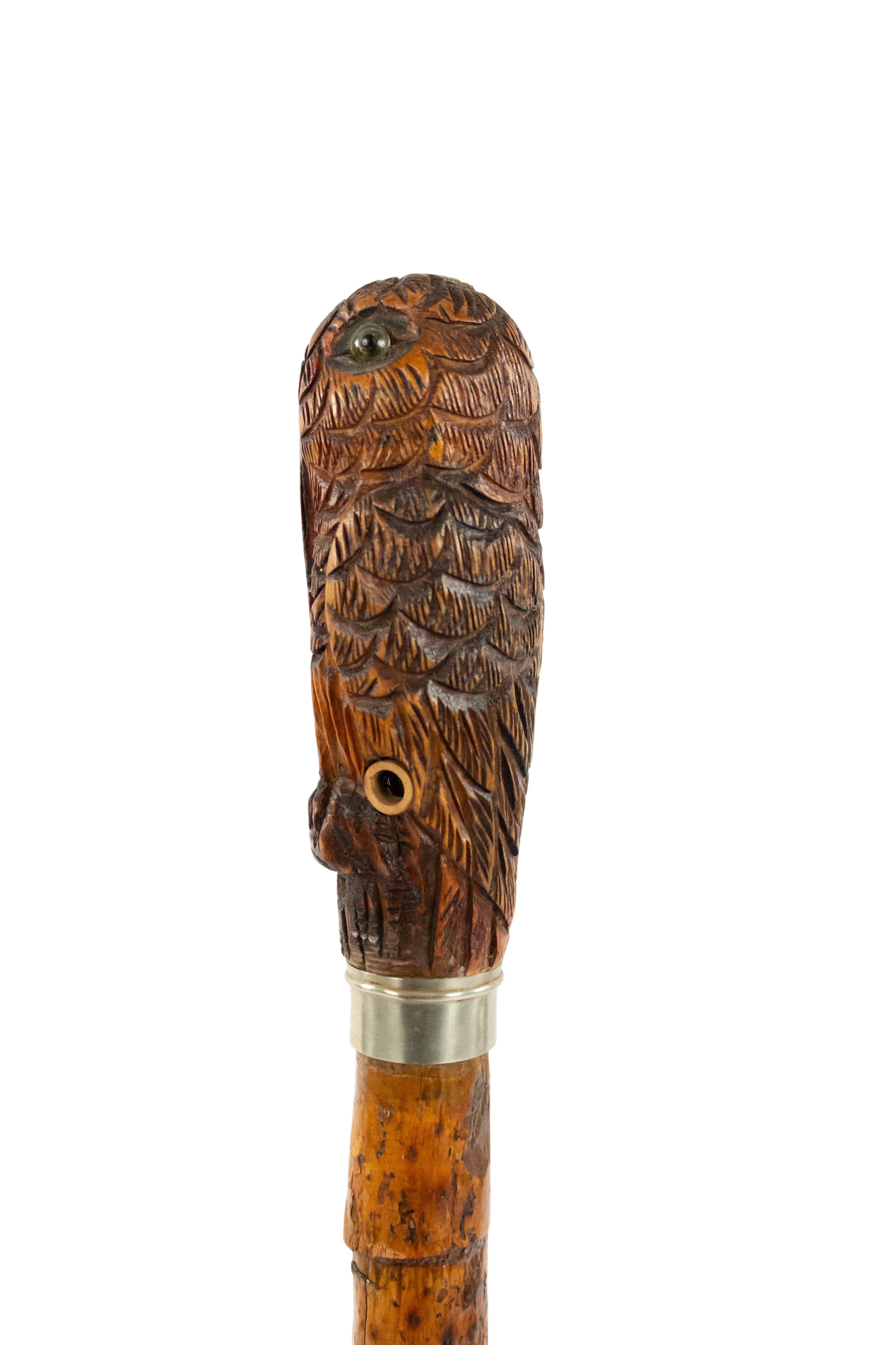 English Victorian bamboo cane having a handle carved as stylized pelican with a silver collar and brass tip.
 