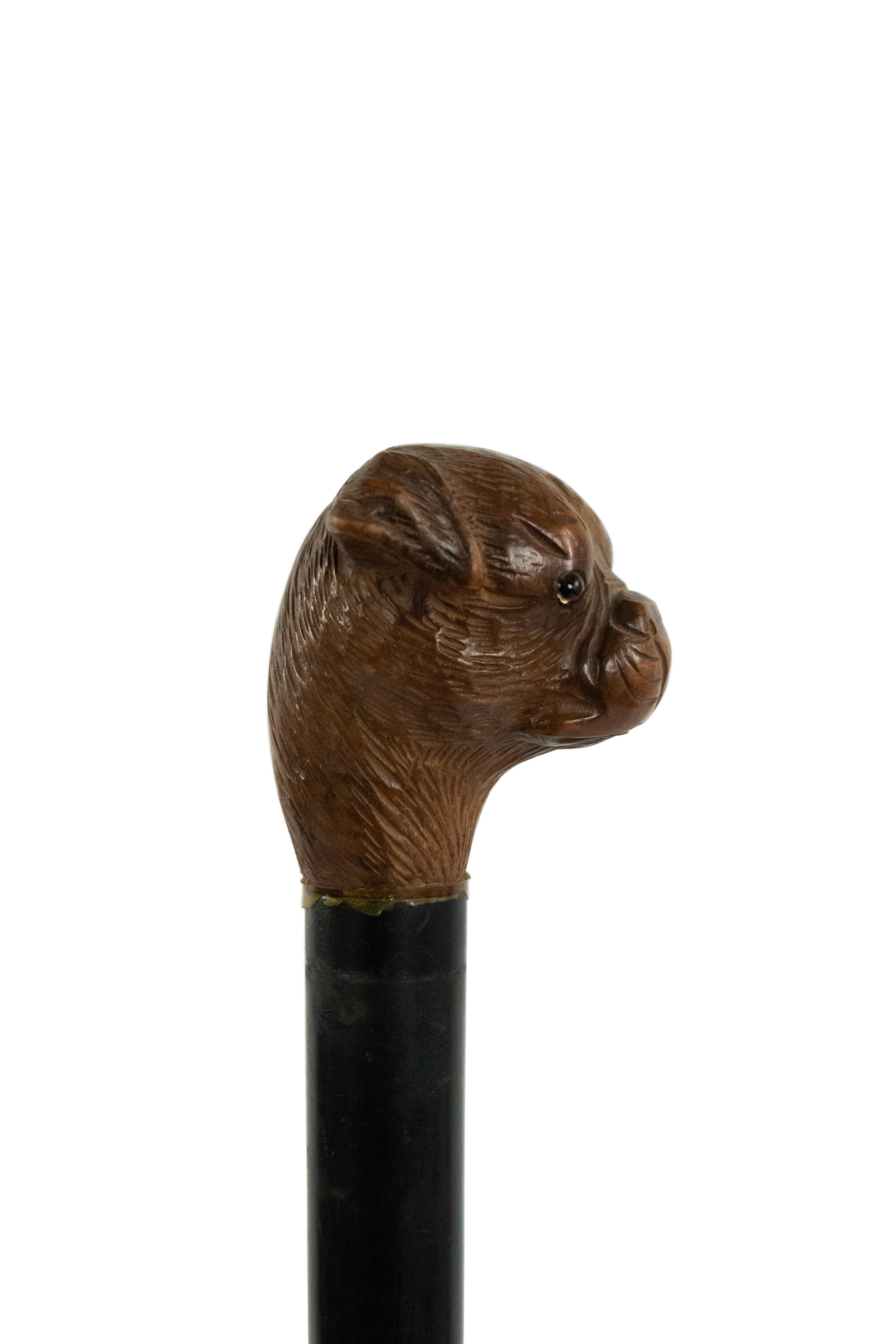 English Victorian walking cane with ebonized shaft and carved bull dog head handle and brass tip.
 