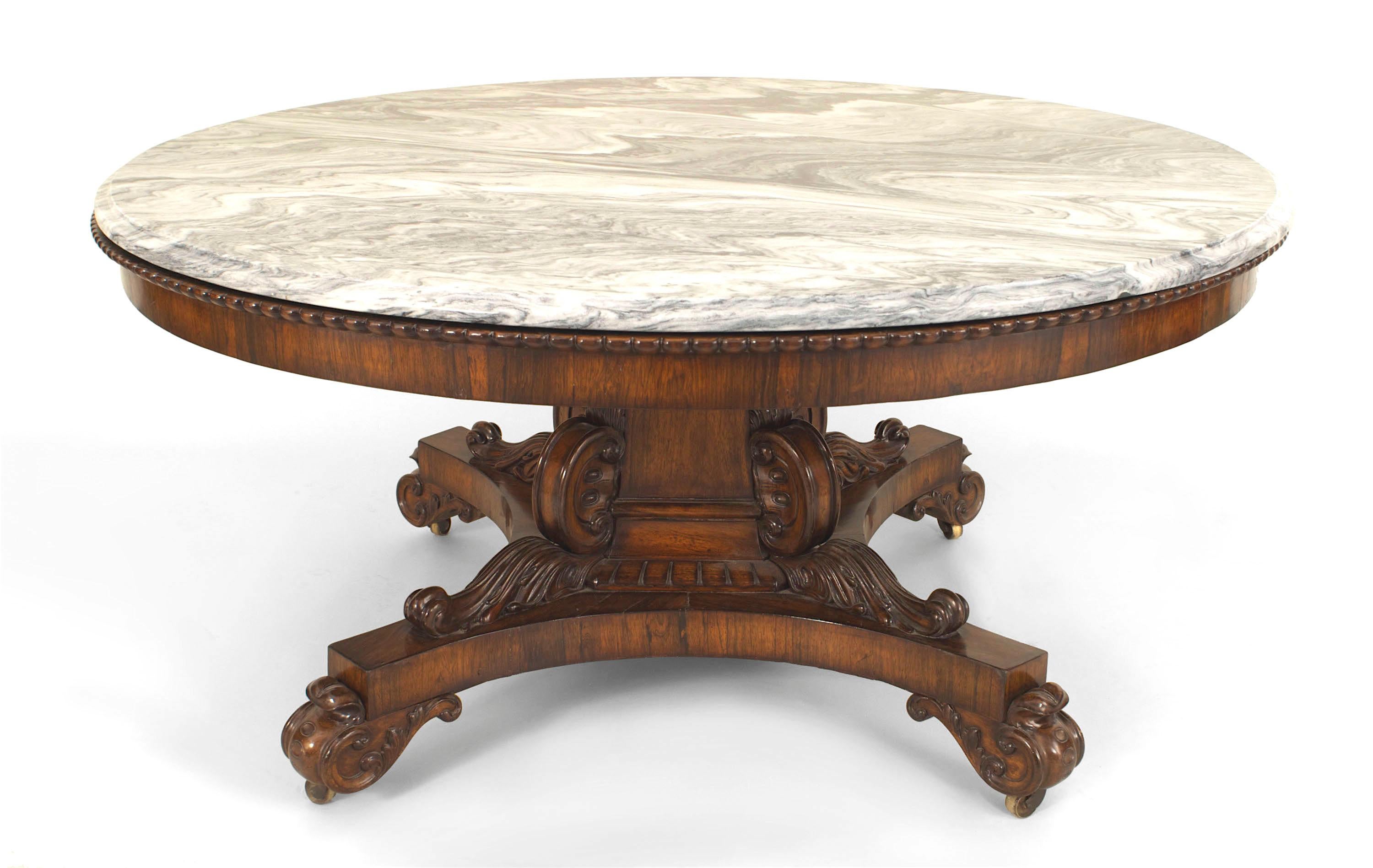 English Regency (1825) mahogany rosewood center table with a 3 sided pedestal base carved with scroll designs resting on caster and supporting a grey St. Anne marble top.
