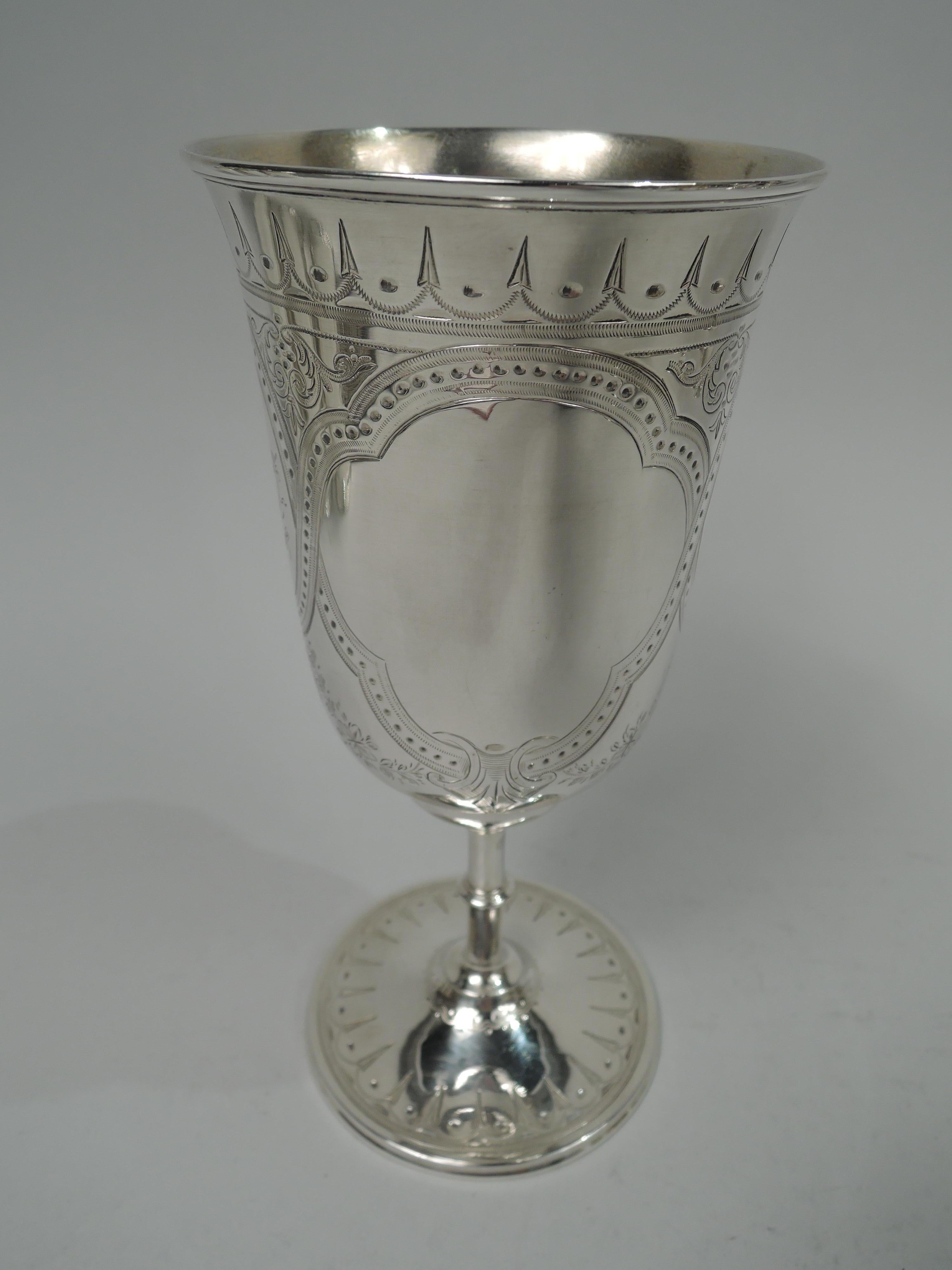 Victorian Classical sterling silver goblet. Made by Henry Wilkinson & Co. in Sheffield in 1870. Tall and tapering bowl with domed bottom, knopped cylindrical stem and round foot. Engraved stylized ornament: pointille strapwork frames of which two