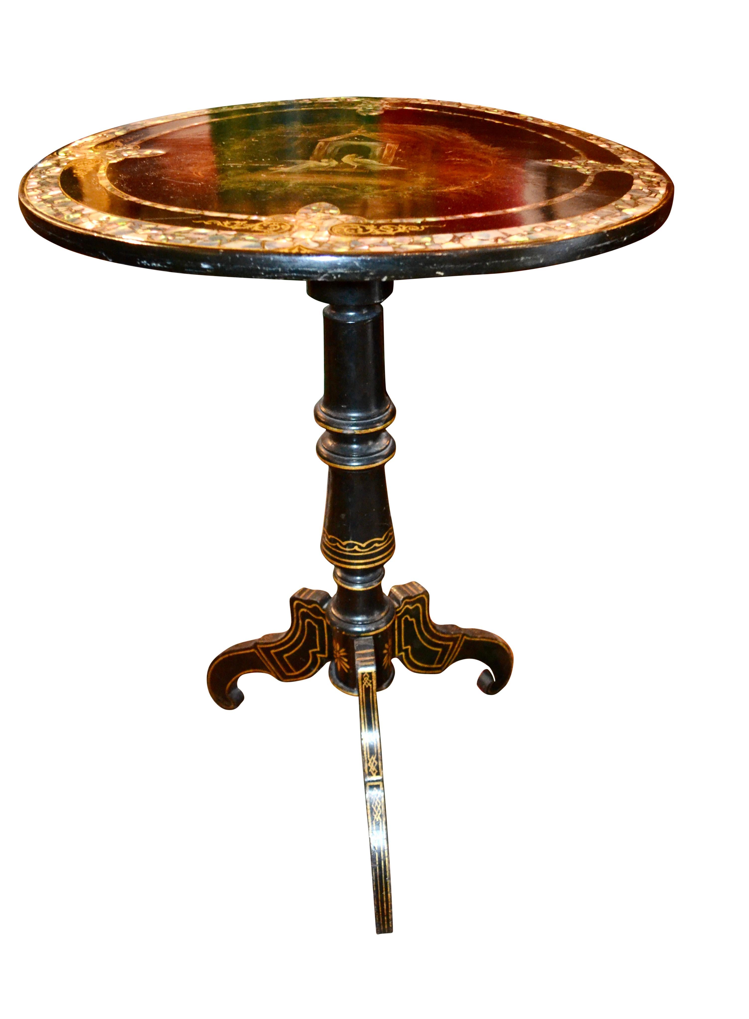 A circular ebonized wood and painted tilt-top occasional table; the top centred by a well painted vignette of two doves symbols of peace and love in front of their temple like birdhouse ; the top rests on a turned ebonized and gilt column on a