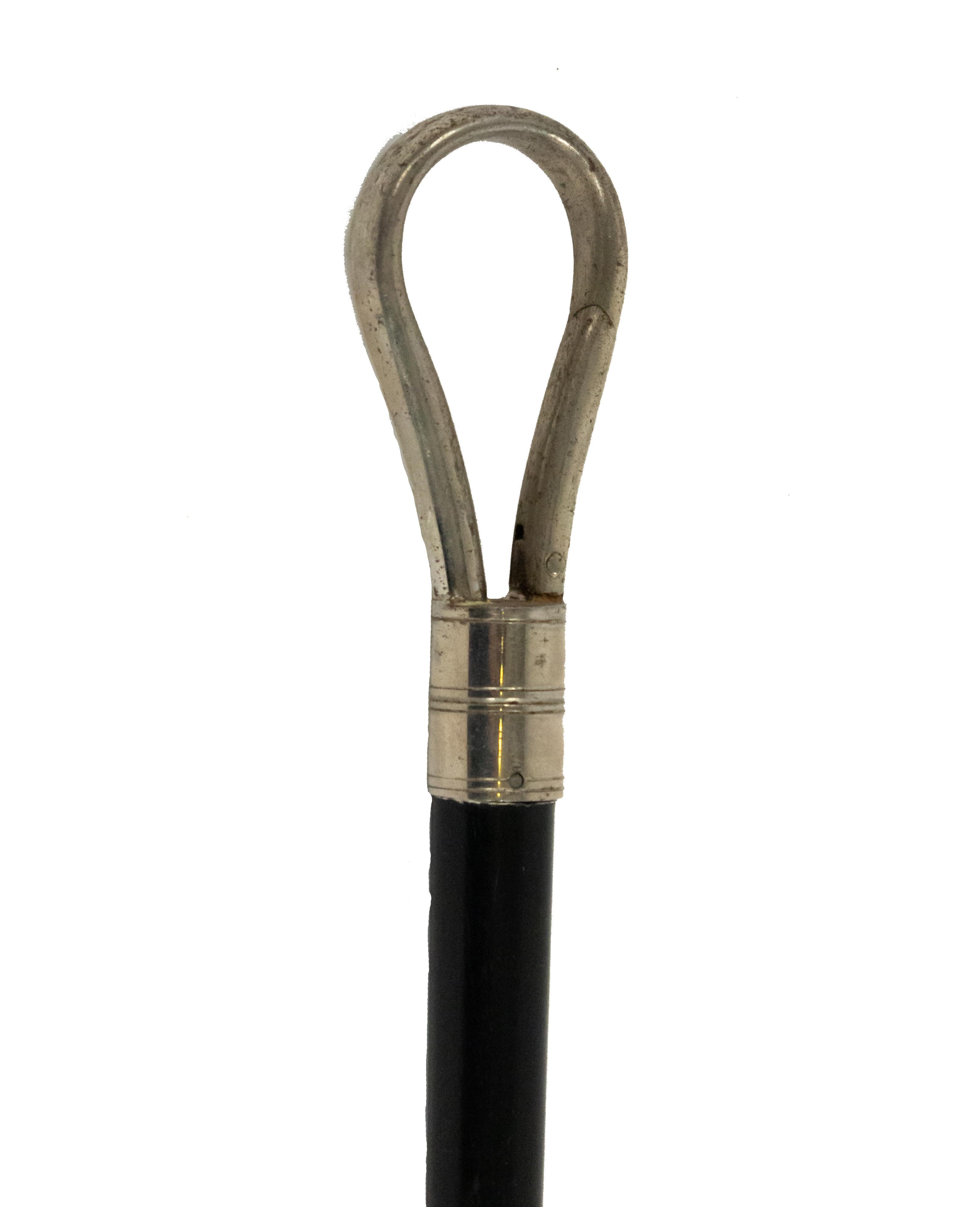 English Victorian ebonized cane with silver stirrup loop top.
 