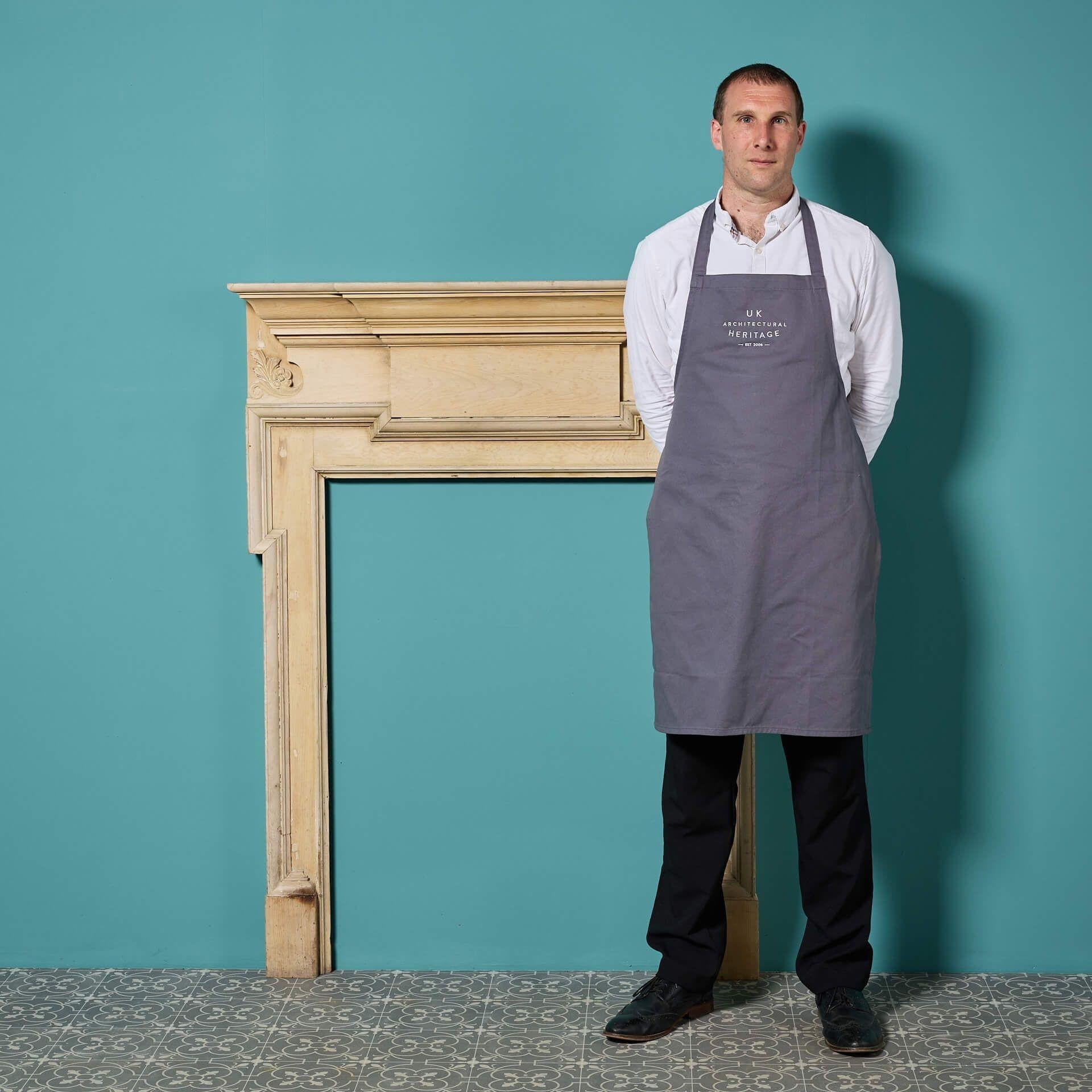 A 19th century English Victorian era stripped pine fireplace, circa 1890. Though simple in design, this antique fire surround exudes grandeur with its dog-leg style framed opening and large centre tablet, the frieze simply decorated with carved