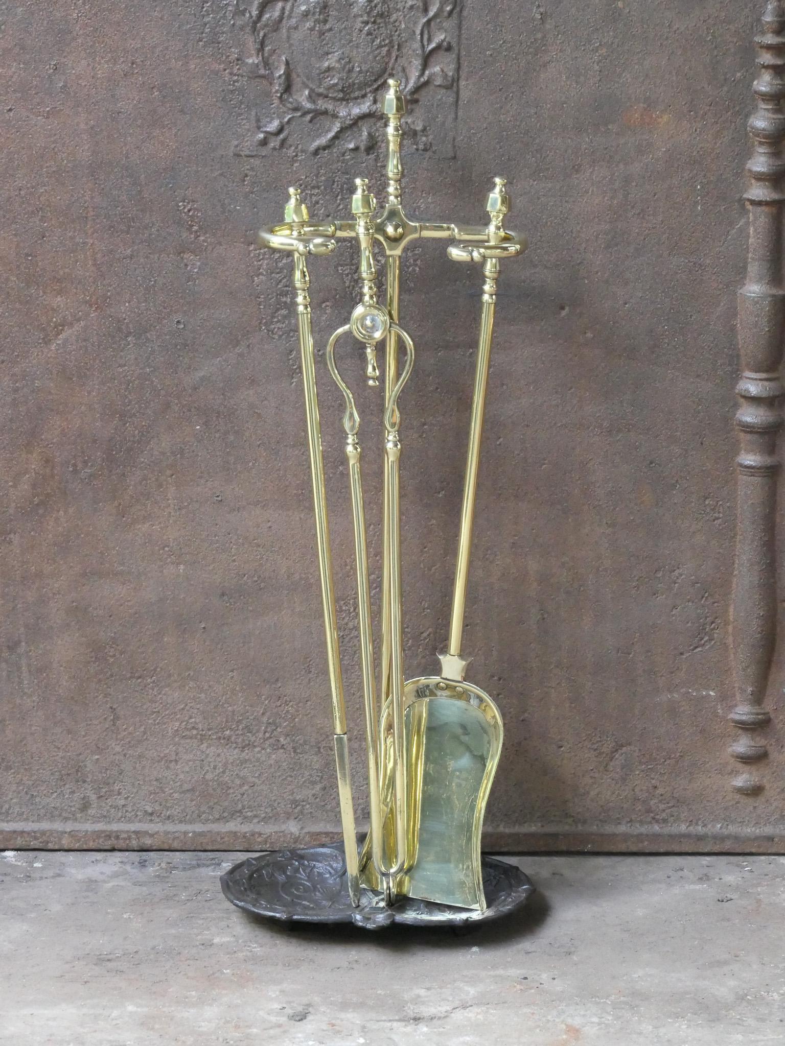 Juego de herramientas para chimenea de la época victoriana inglesa del siglo XIX. Las herramientas son de latón pulido, y el soporte, de hierro fundido con latón pulido. El juego de herramientas consta de pinzas, pala, atizador y soporte. El estado
