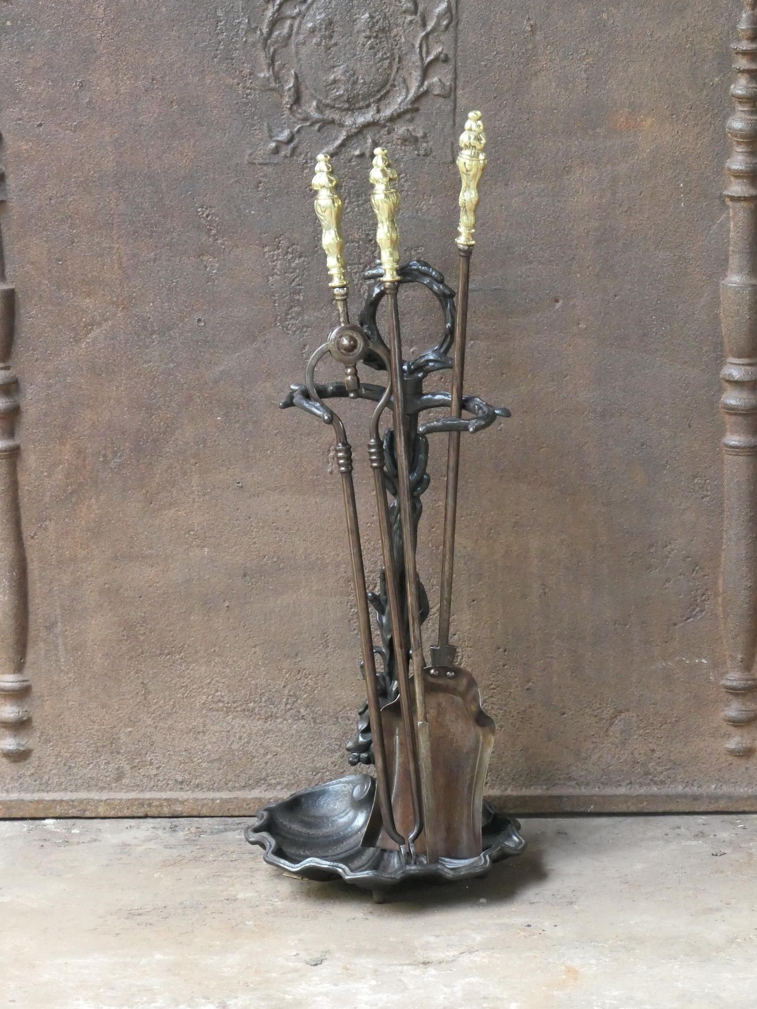 Set di attrezzi per caminetto del XIX secolo in stile vittoriano inglese. Gli utensili sono realizzati in ferro battuto con manici in ottone lucido, mentre il supporto è in ghisa. Il set di attrezzi è composto da pinze, pala, attizzatoio e supporto.